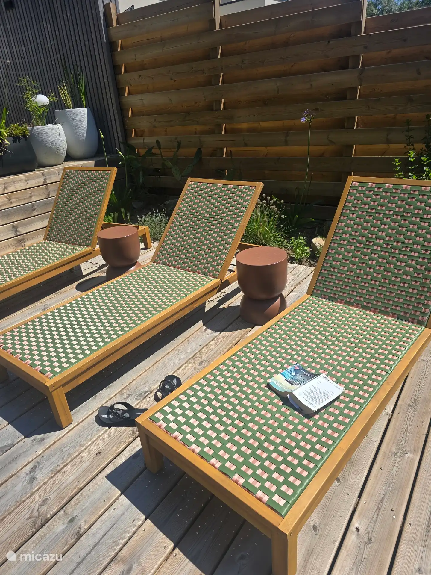 Espace détente extérieur avec bains de soleil, idéal pour se relaxer au soleil dans un cadre verdoyant et paisible.