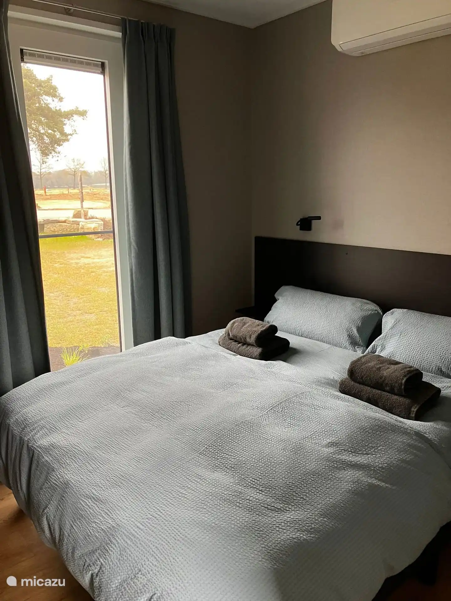 Spacious bedroom with double bed. There is an air conditioner. 