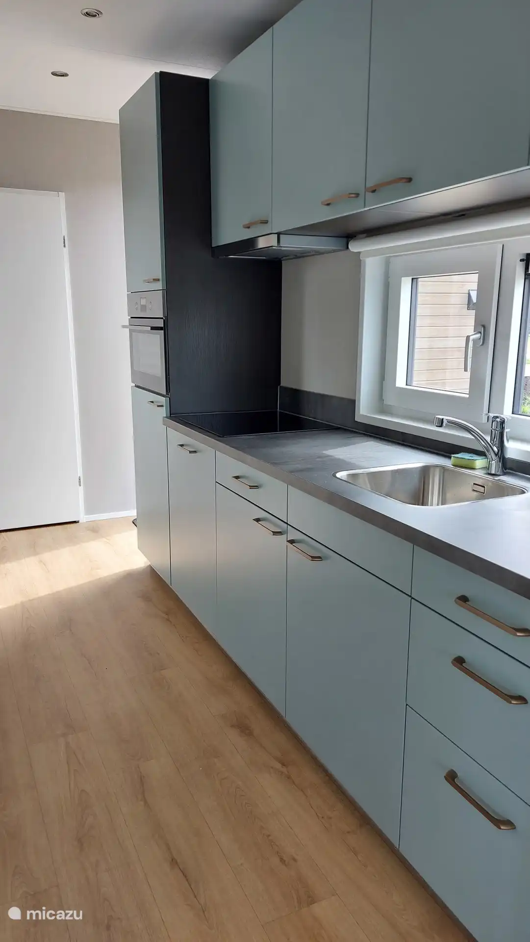 Modern kitchen with oven, refrigerator, dishwasher and extensive kitchen utensils. 