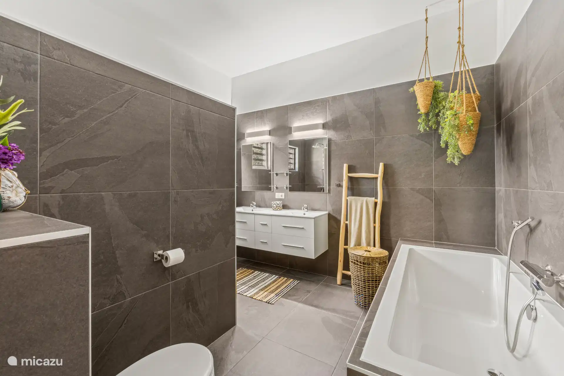 Luxe badkamer met ligbad, dubbele wastafel en een aparte douche voor extra comfort.