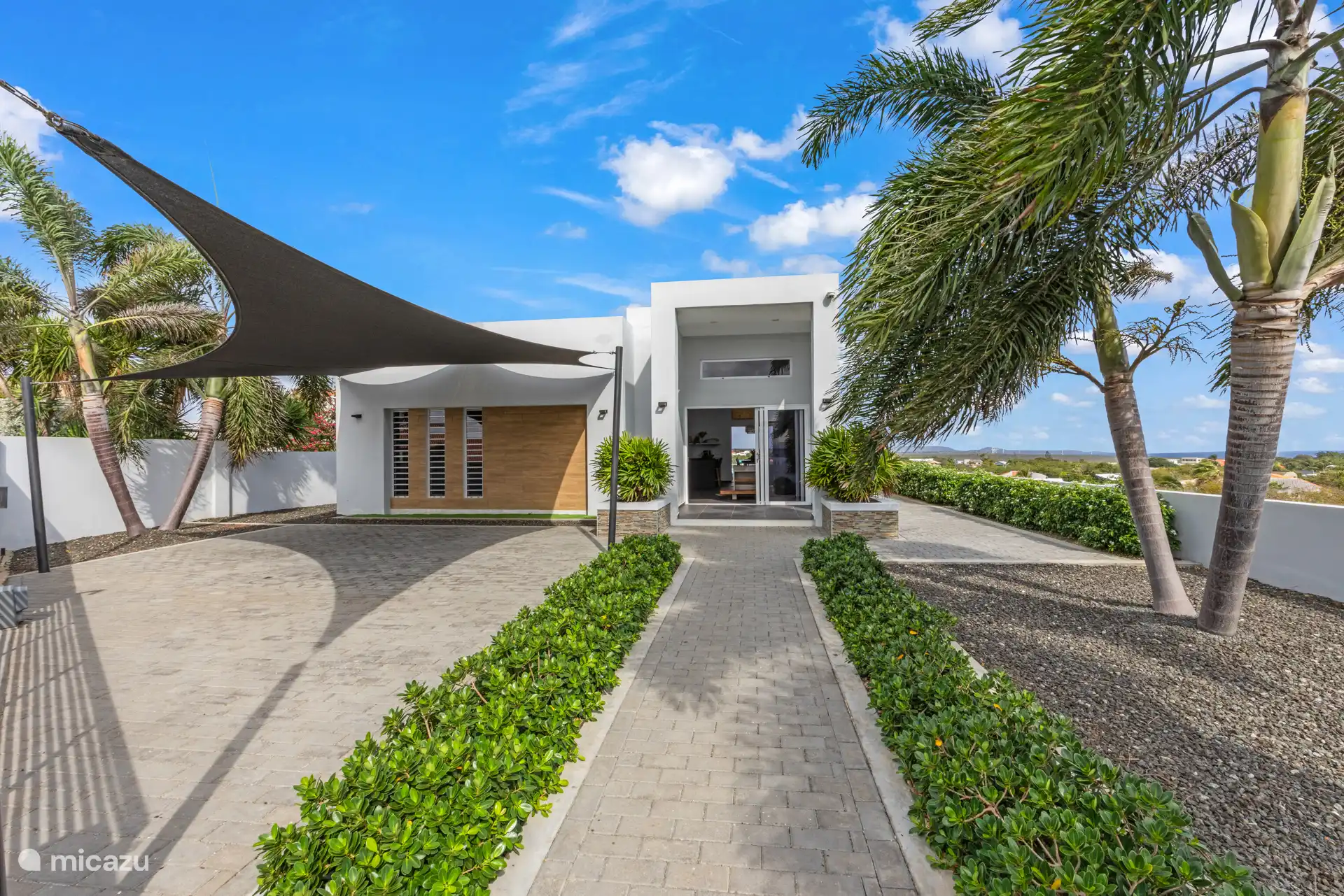 Ruime voortuin met schaduwdoek, ideaal om je auto koel en beschut te parkeren