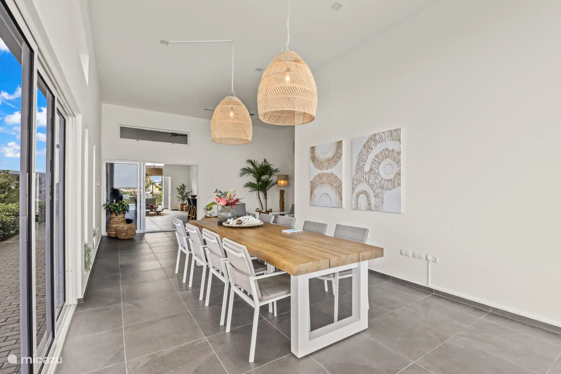 Vanuit de eettafel kijk je zo de woonkamer in, waarbij alles open kan en binnen en buiten mooi in elkaar overlopen