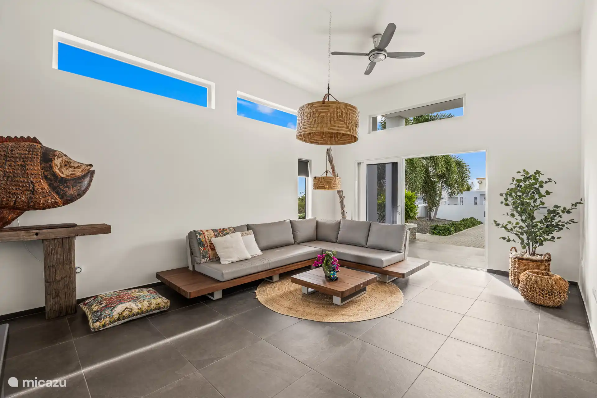 Lichte woonkamer met royale bank en openslaande deuren naar de voortuin voor een heerlijk open gevoel