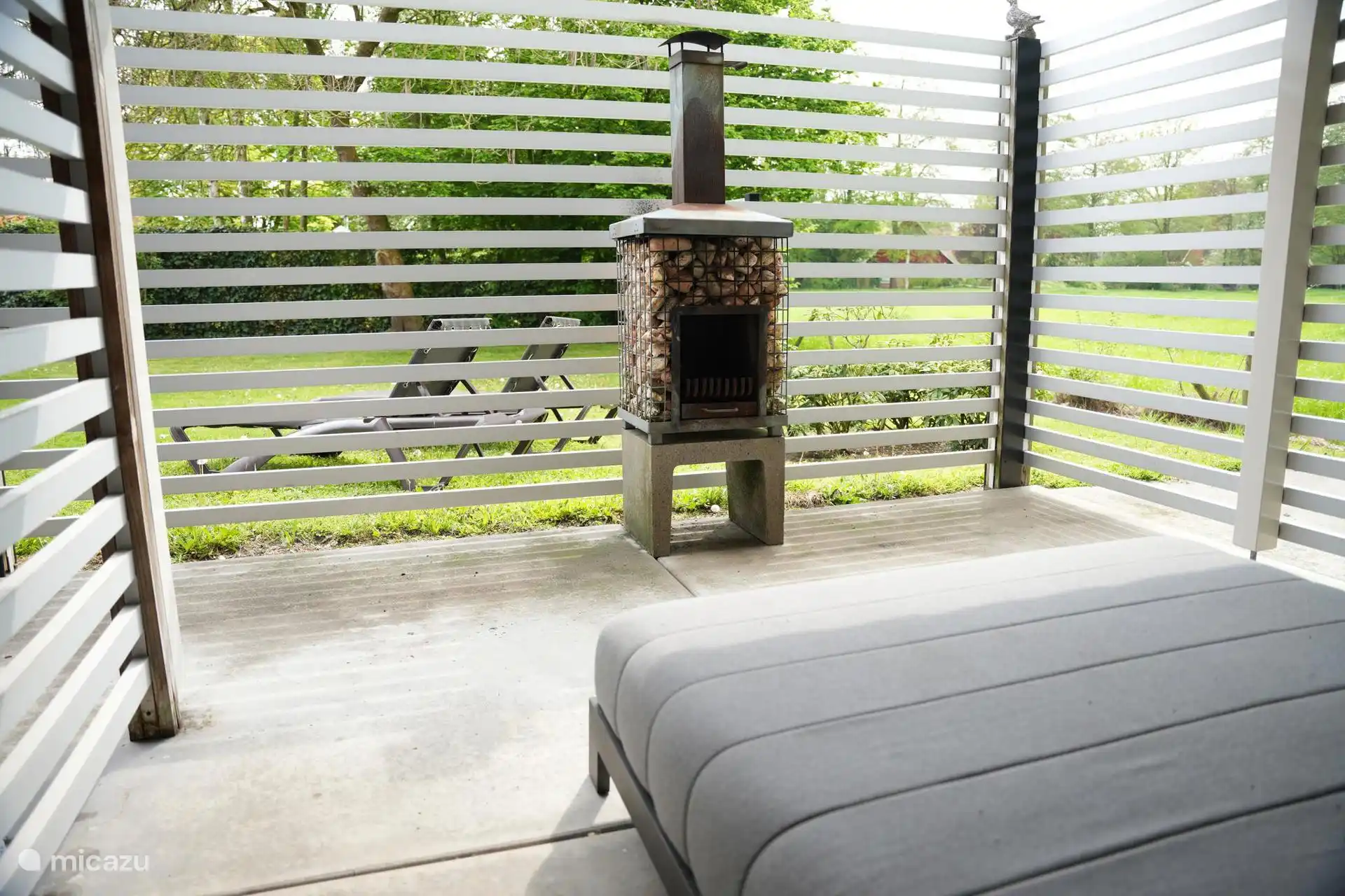 Ligbed met uitzicht op een buitenhaard