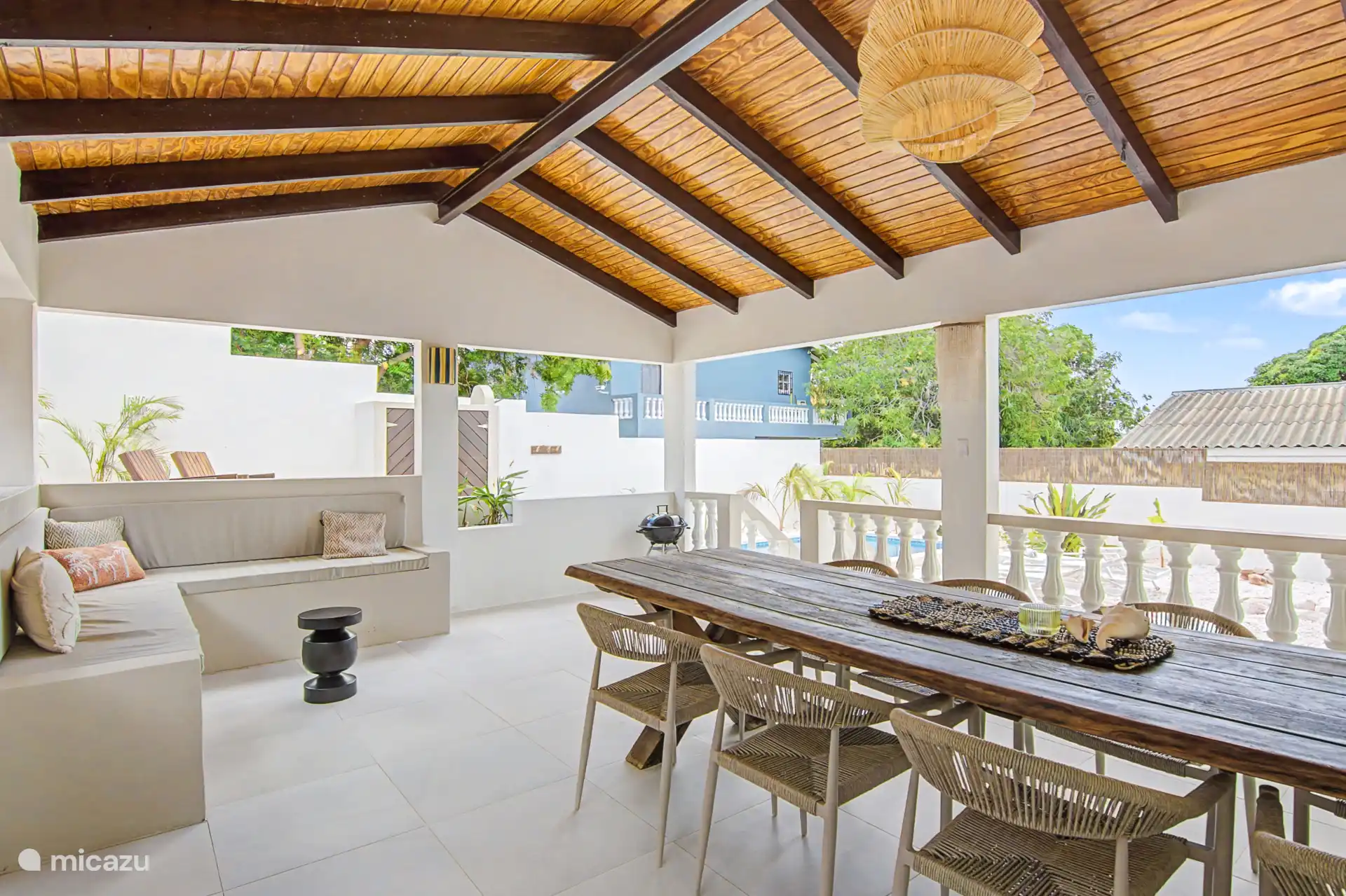 Buitenruimte met zithoek, tafel met 8 stoelen