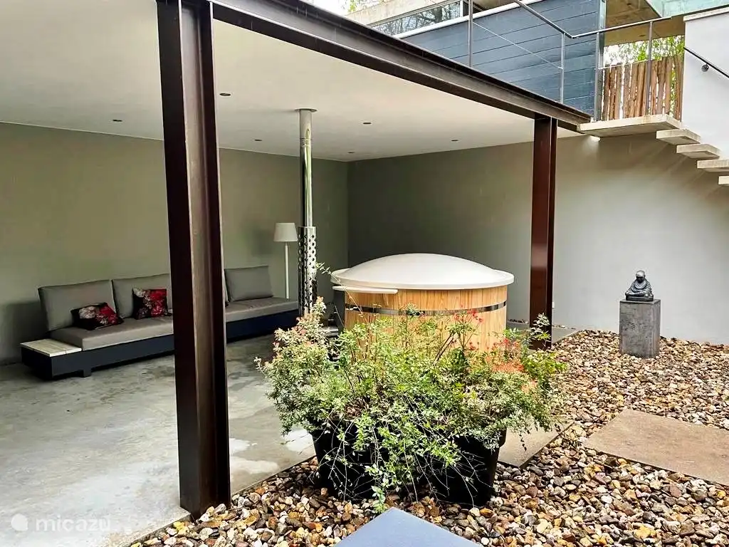 Terrace downstairs with lounge sofa and covered hot tub