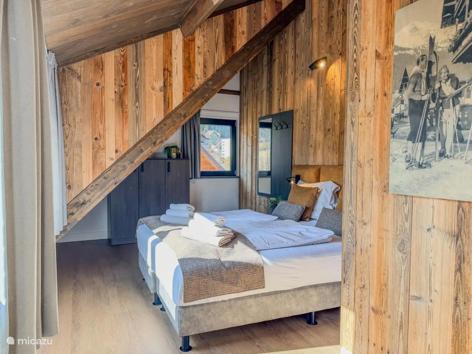 Slaapkamer met uitzicht op de natuur buiten. 