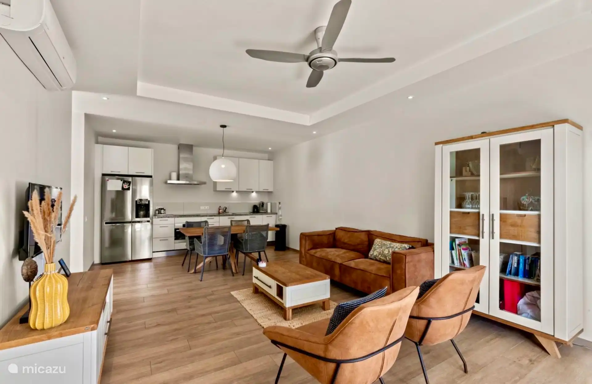 Un salón espacioso y encantador con puertas de patio que dan a la terraza con vistas al jardín tropical y mucha privacidad.