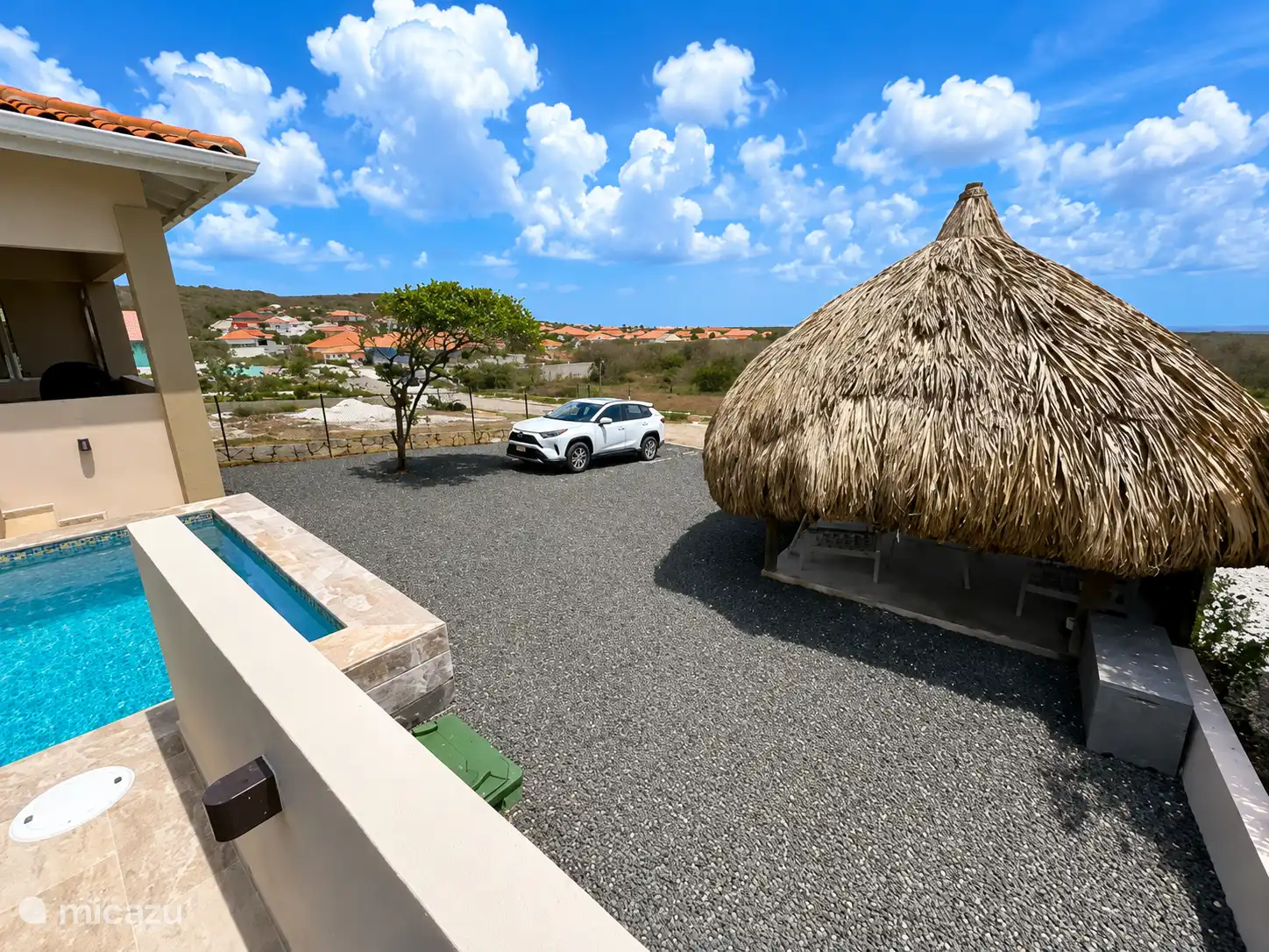 Jardín delantero con palapa y aparcamiento