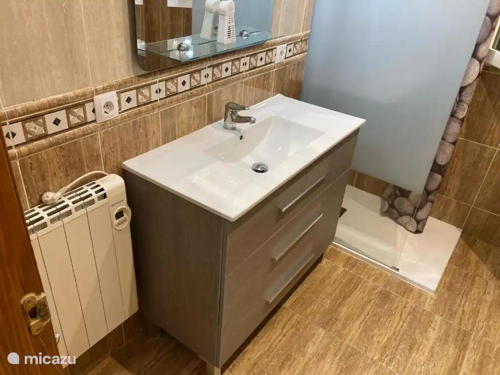 Badkamer met douche en bad