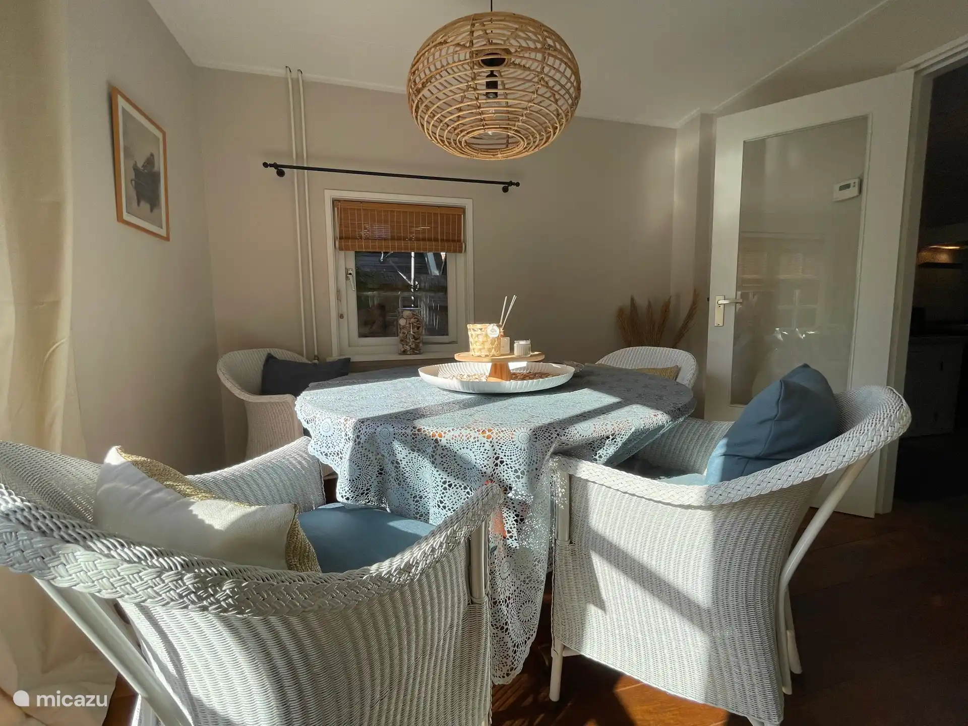 Helles Wohnzimmer, ausgestattet mit Esstisch, Sitzecke, Fernseher und gemütlichem Kamin.