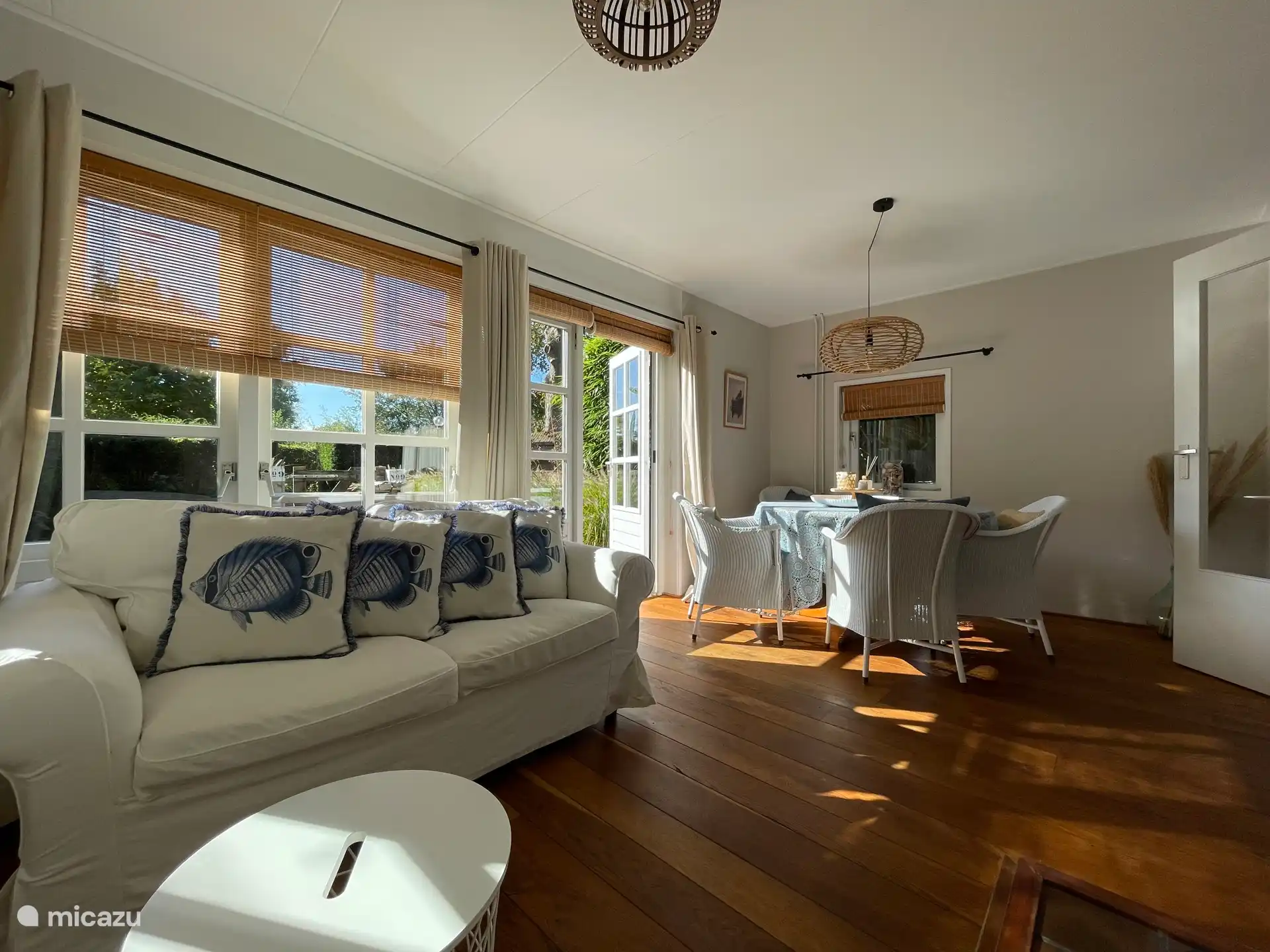 Helles Wohnzimmer, ausgestattet mit Esstisch, Sitzecke, Fernseher und gemütlichem Kamin.