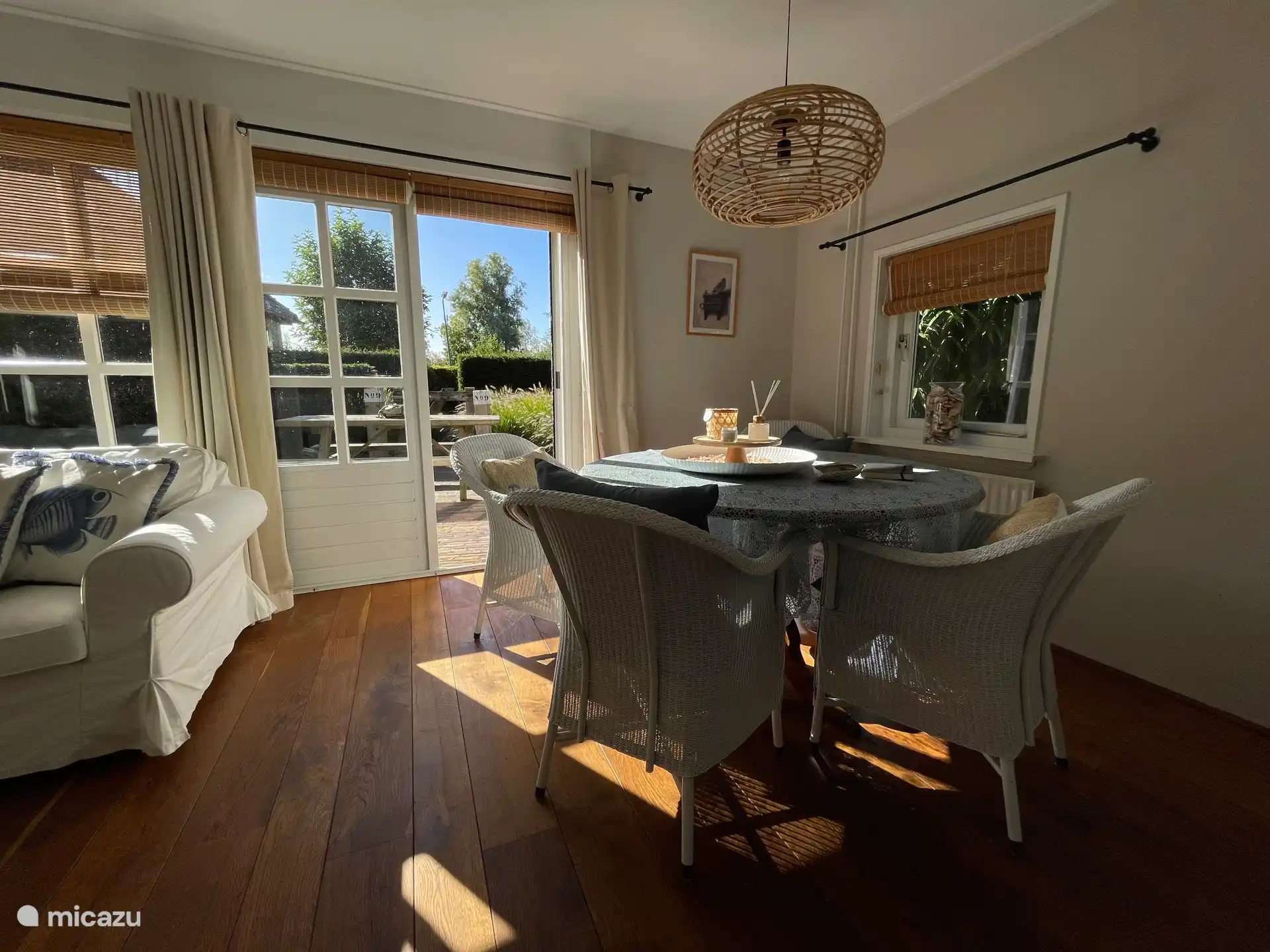 Helles Wohnzimmer, ausgestattet mit Esstisch, Sitzecke, Fernseher und gemütlichem Kamin.