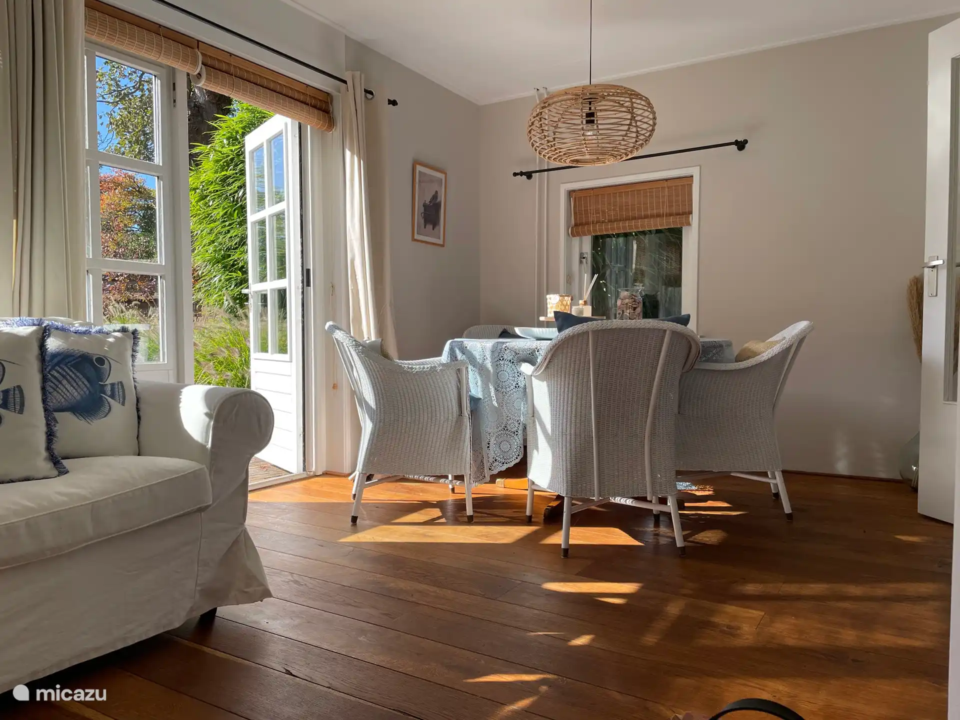 Helles Wohnzimmer, ausgestattet mit Esstisch, Sitzecke, Fernseher und gemütlichem Kamin.