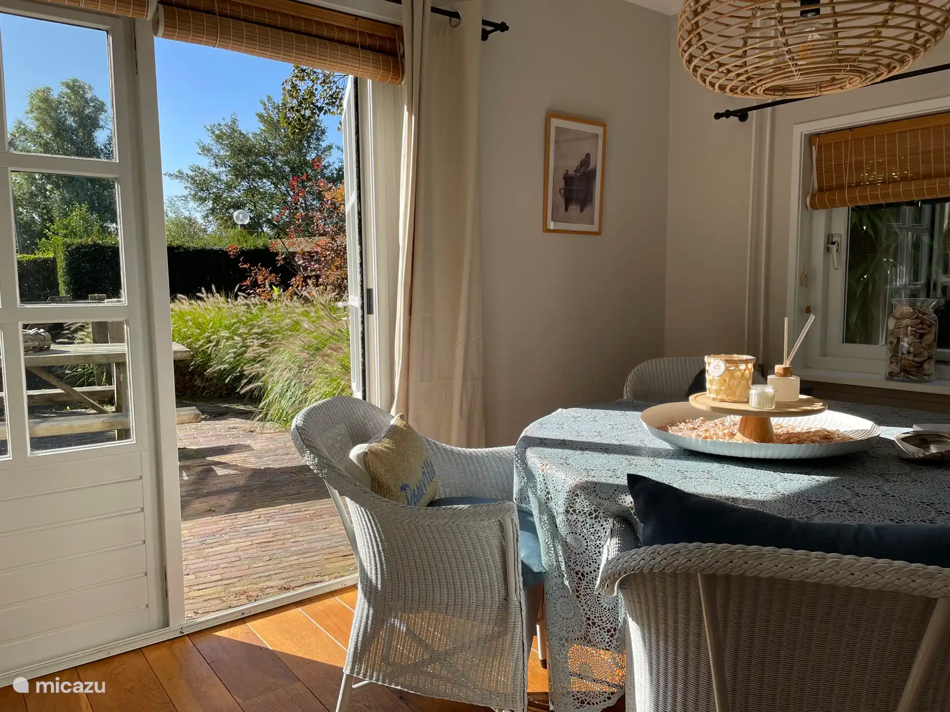 Helles Wohnzimmer, ausgestattet mit Esstisch, Sitzecke, Fernseher und gemütlichem Kamin.