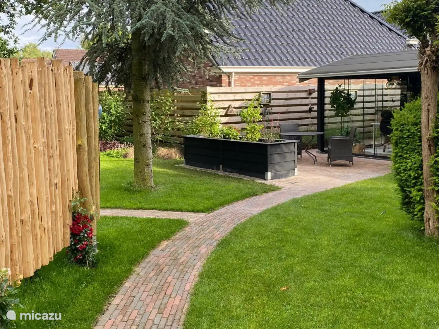 De ruime, gezellige tuinkamer voor het huisje is volledig van glas en voorzien van een terrasverwarmer. 