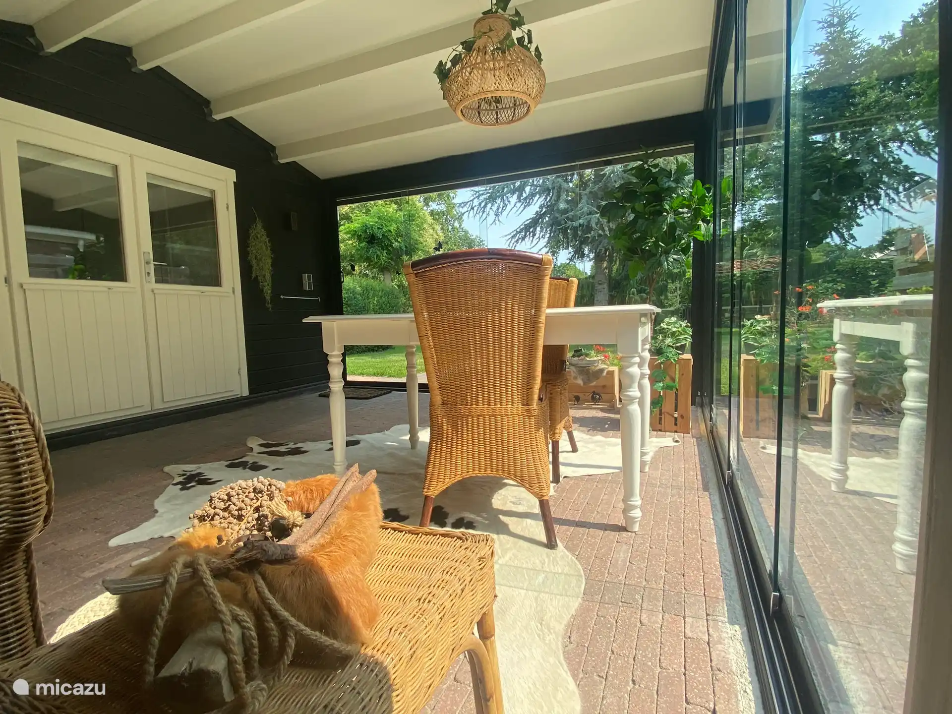 De ruime, gezellige tuinkamer voor het huisje is volledig van glas en voorzien van een terrasverwarmer. 