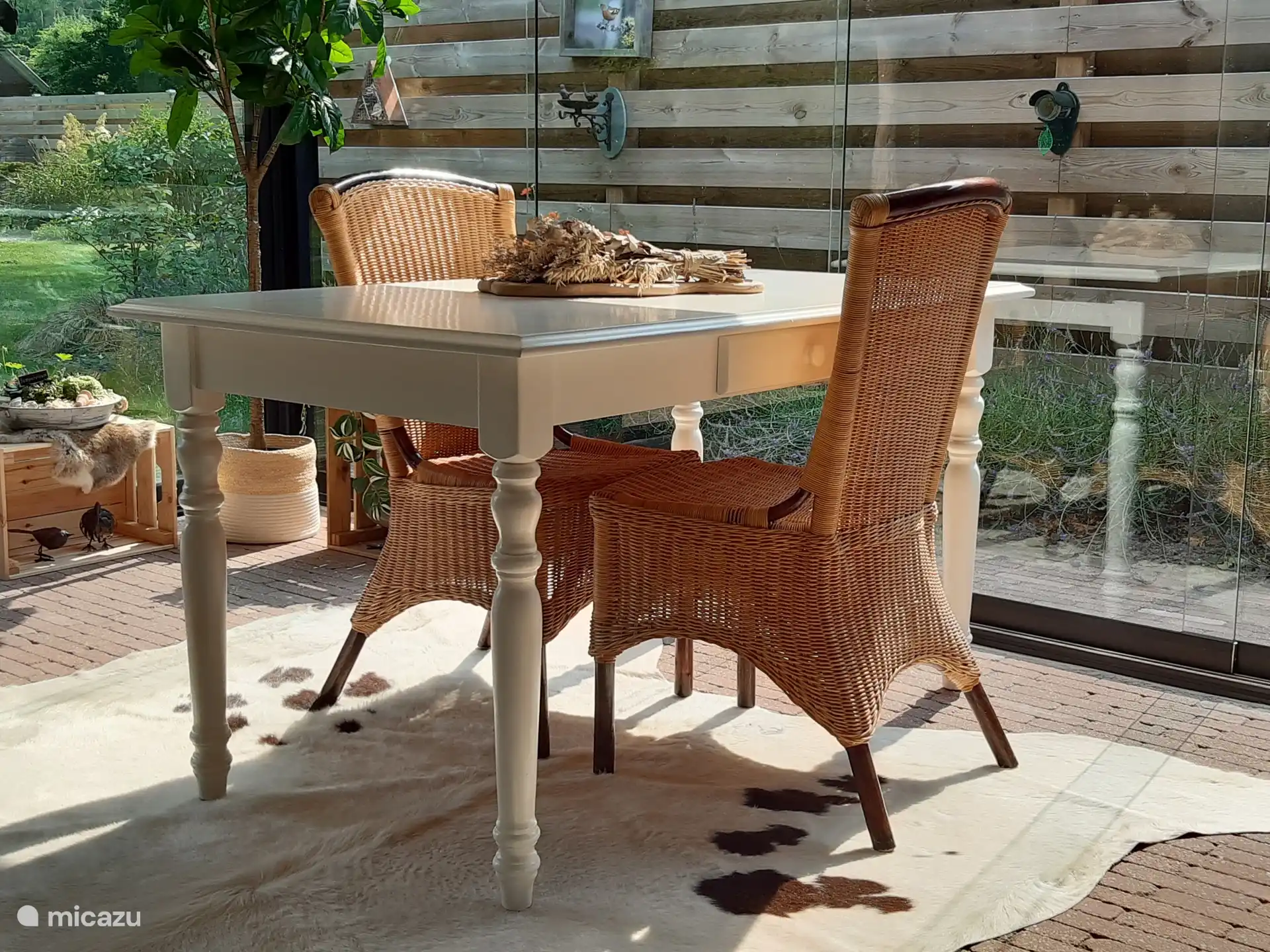 De ruime, gezellige tuinkamer voor het huisje is volledig van glas en voorzien van een terrasverwarmer. 