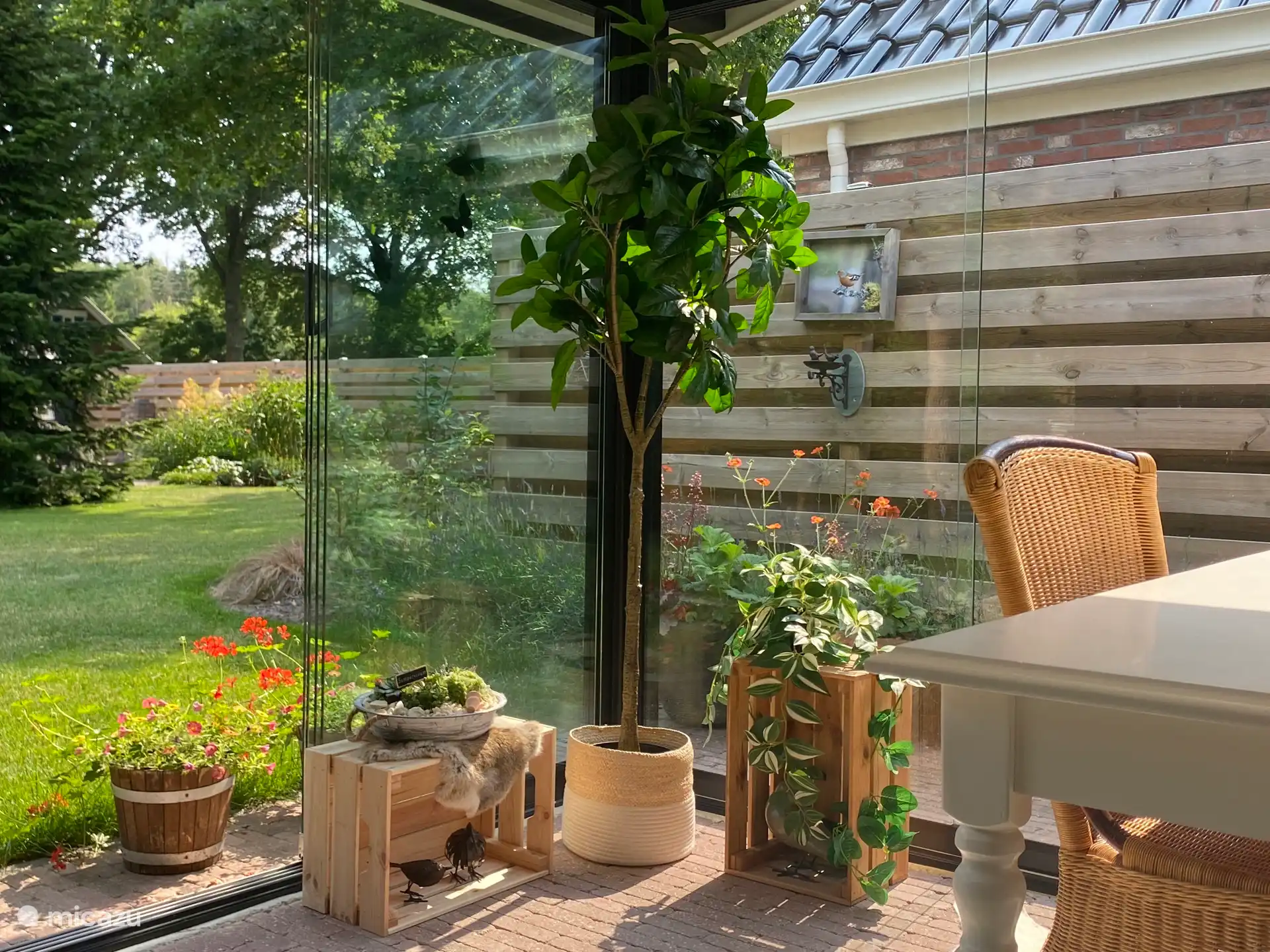 De ruime, gezellige tuinkamer voor het huisje is volledig van glas en voorzien van een terrasverwarmer. 