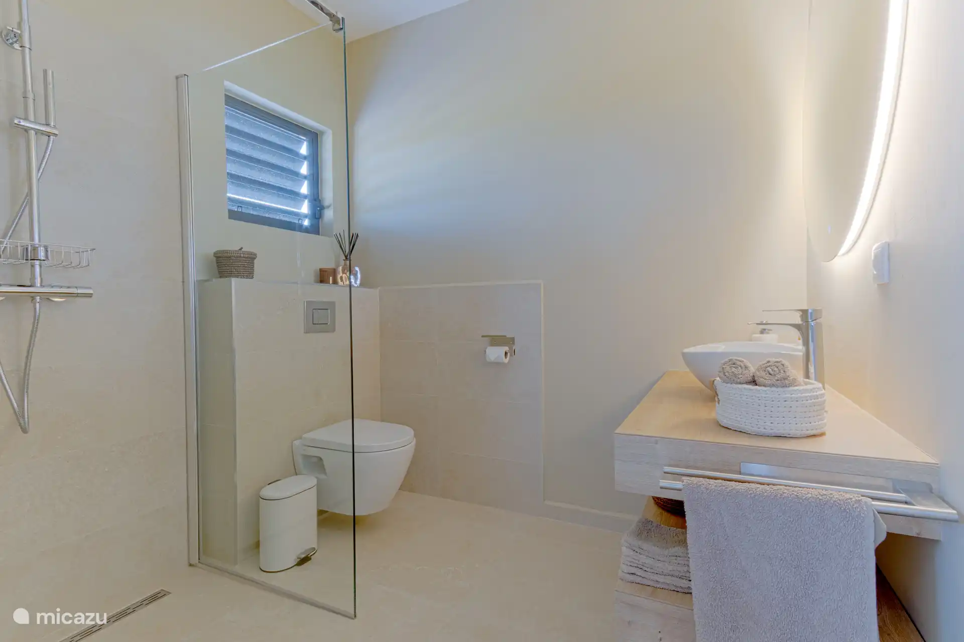 Belle salle de bain spacieuse avec toilettes suspendues et unité murale.