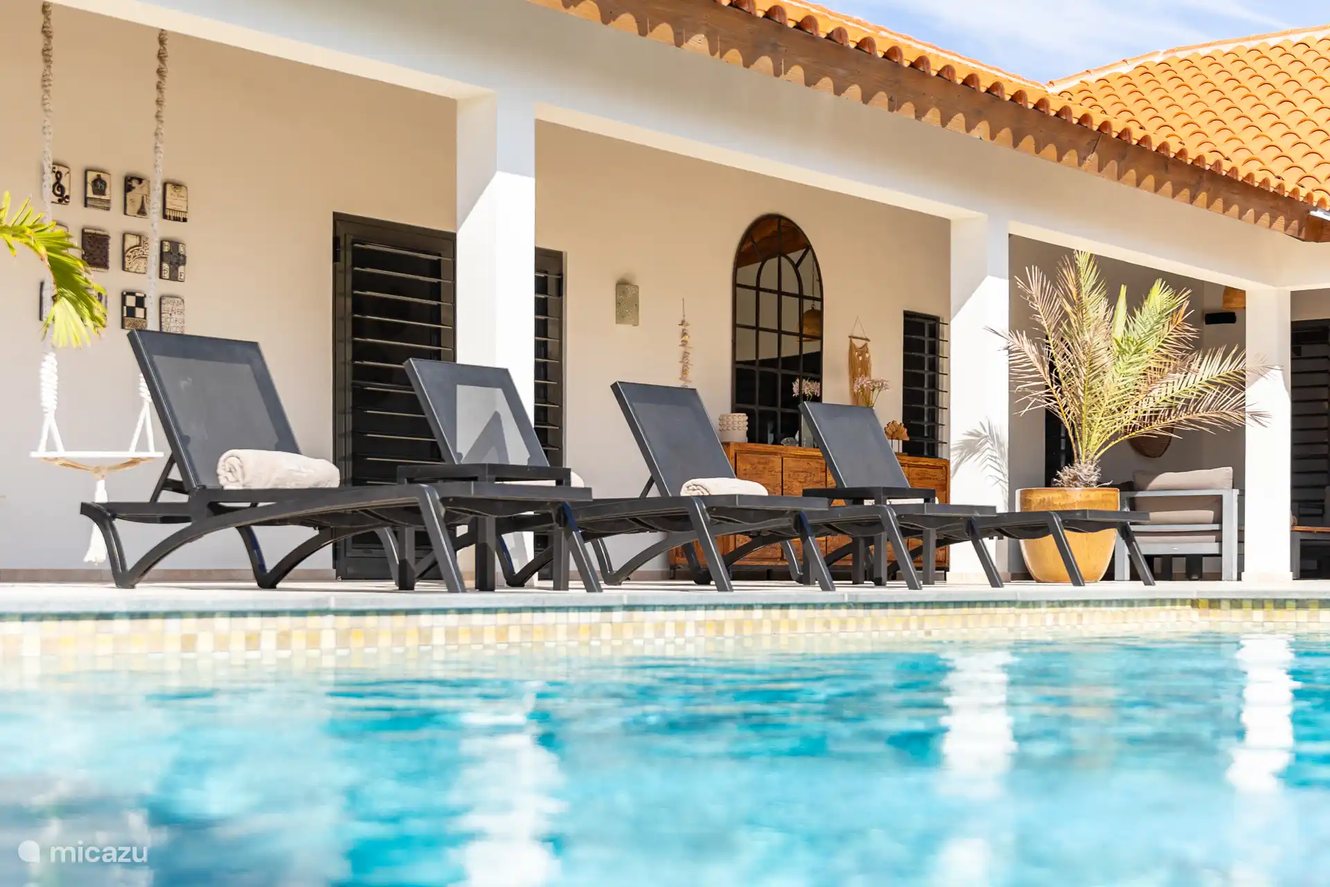 Terrasse de piscine avec transats.