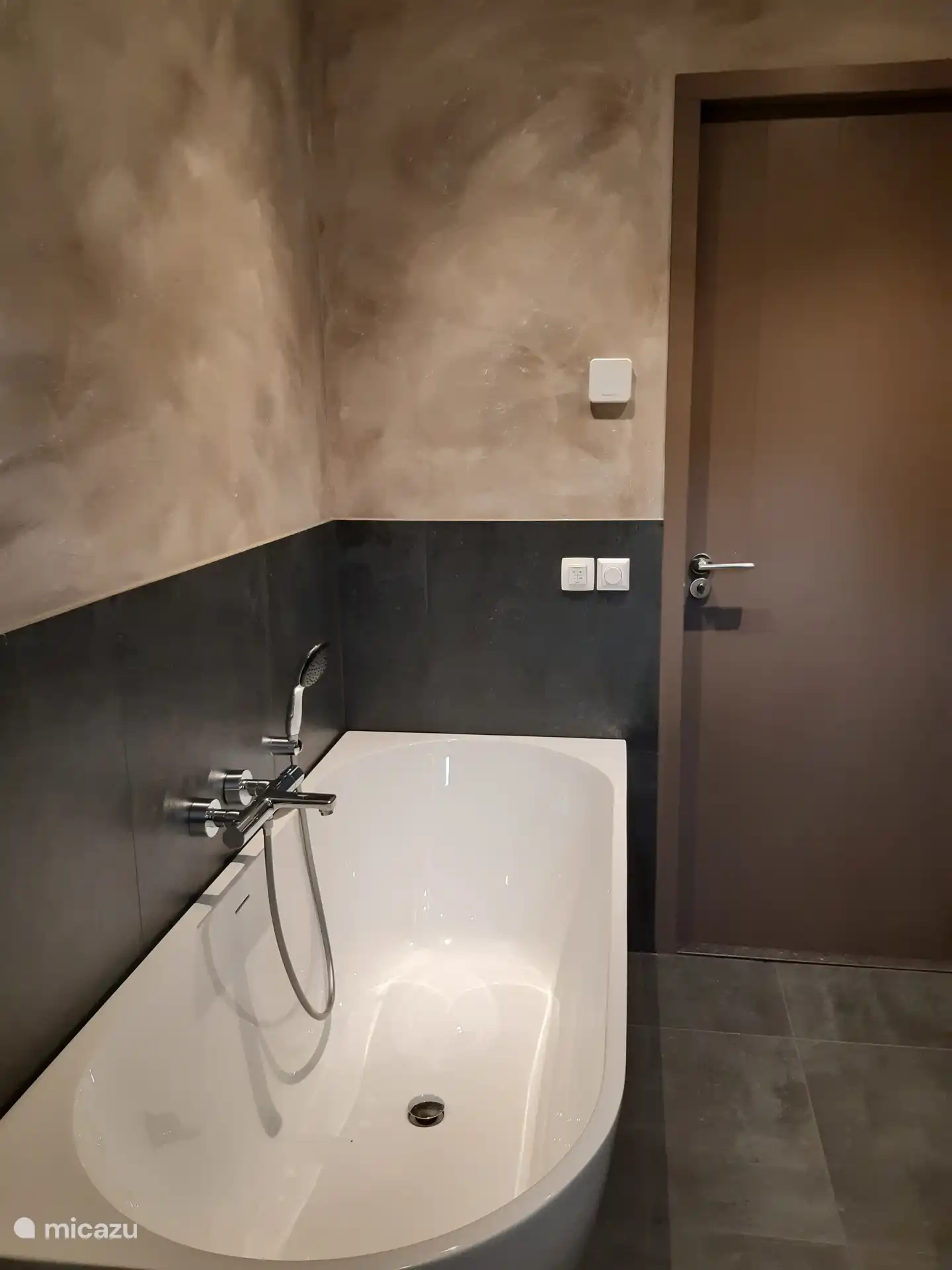 Badkamer heeft een vrijstaand ligbad