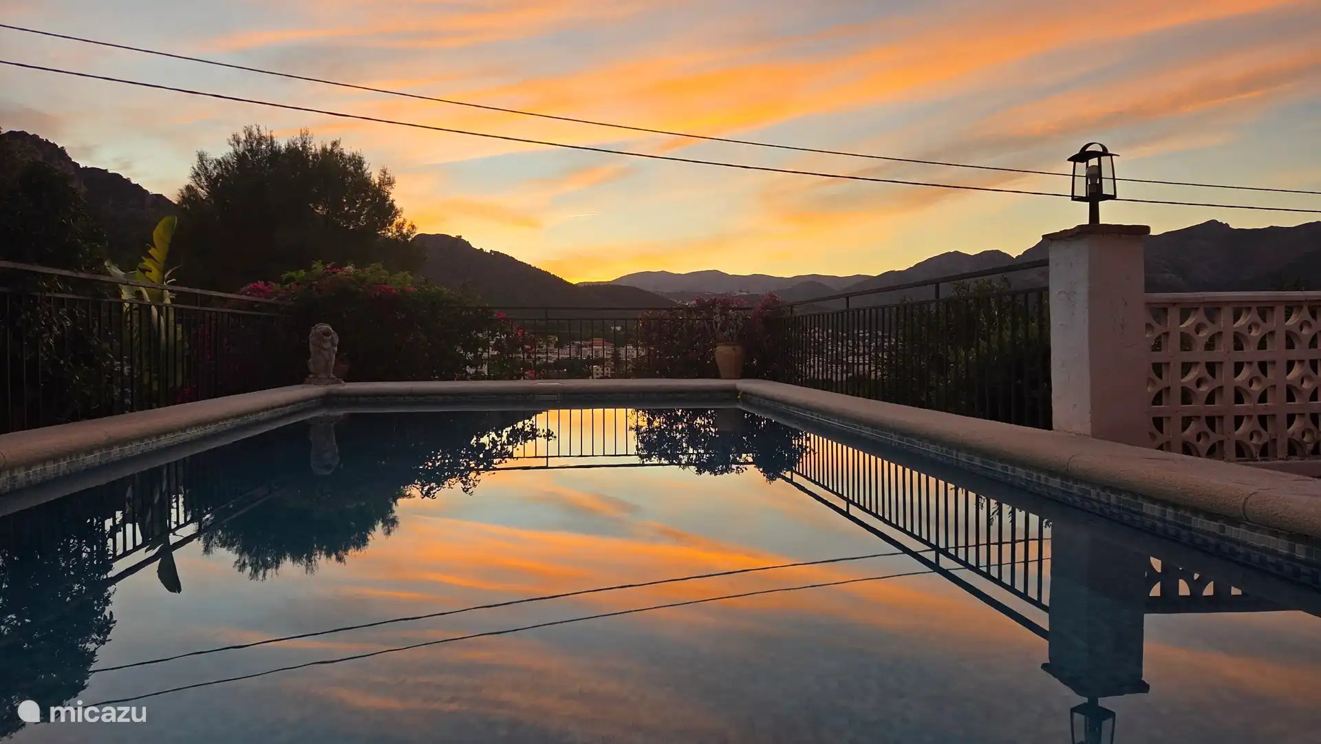 Piscina con puesta de sol detrás de las montañas