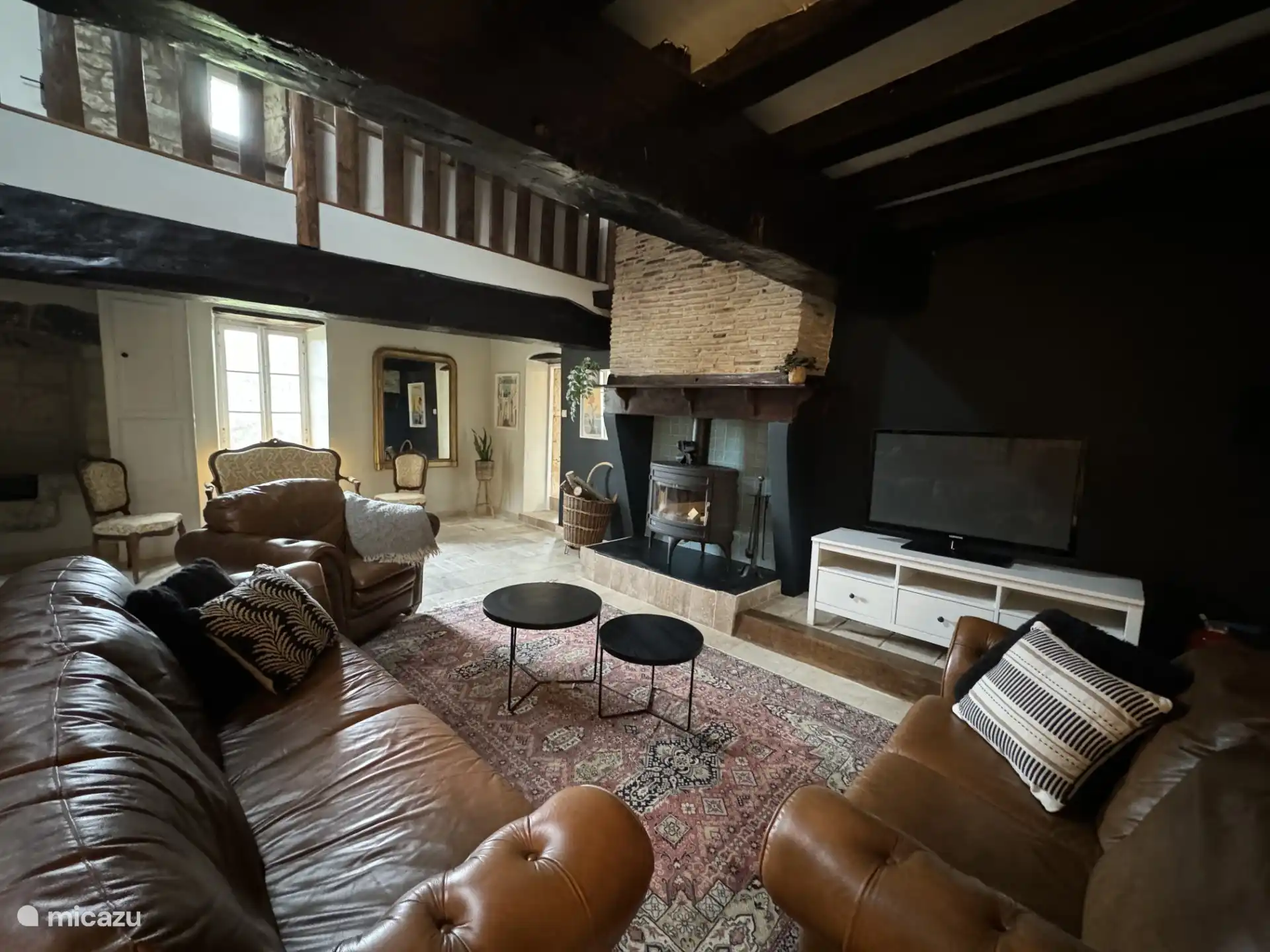Cozy living room with comfortable sitting area and wood stove.
