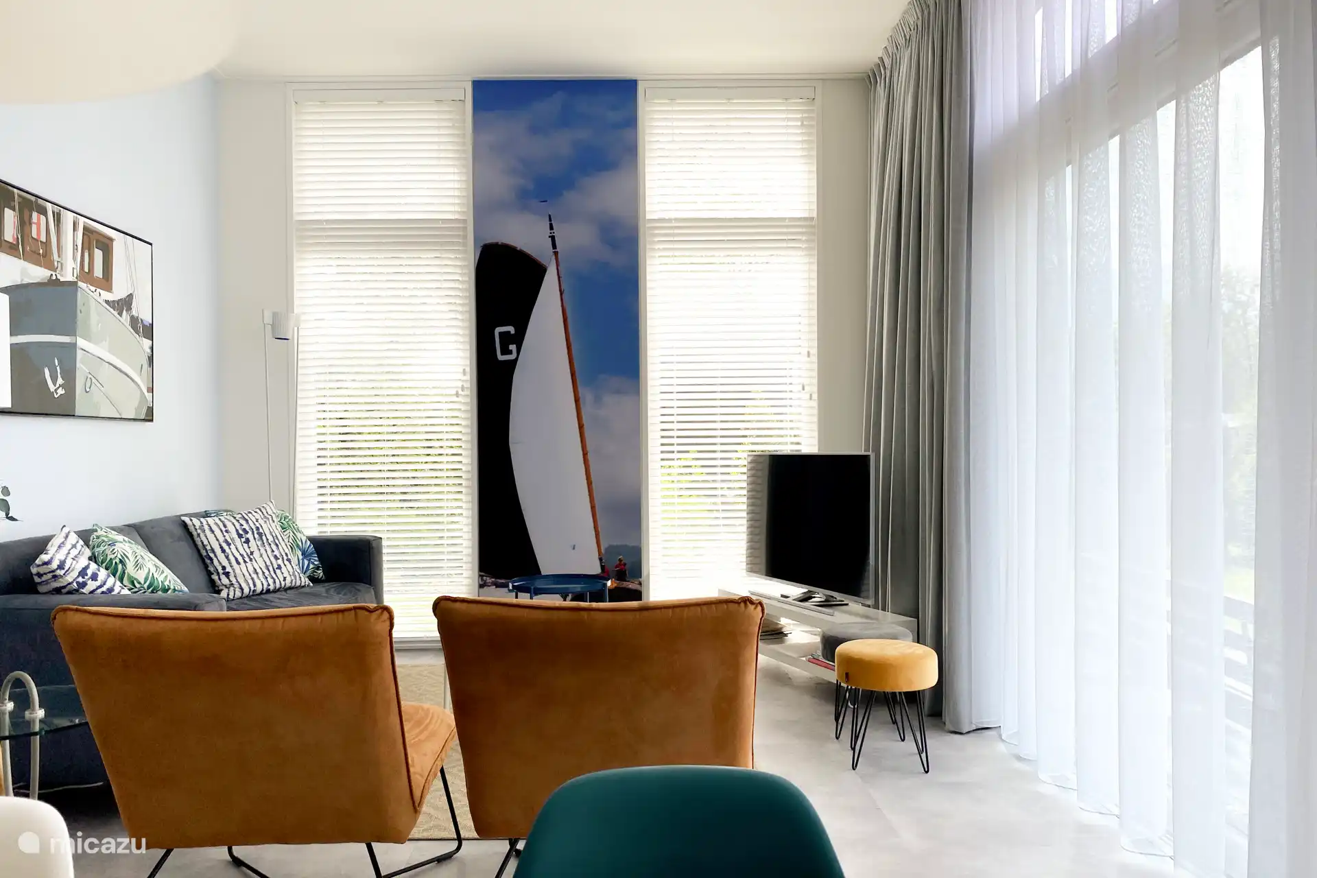 Lichte woonkamer met smart TV en heerlijke bank en stoelen