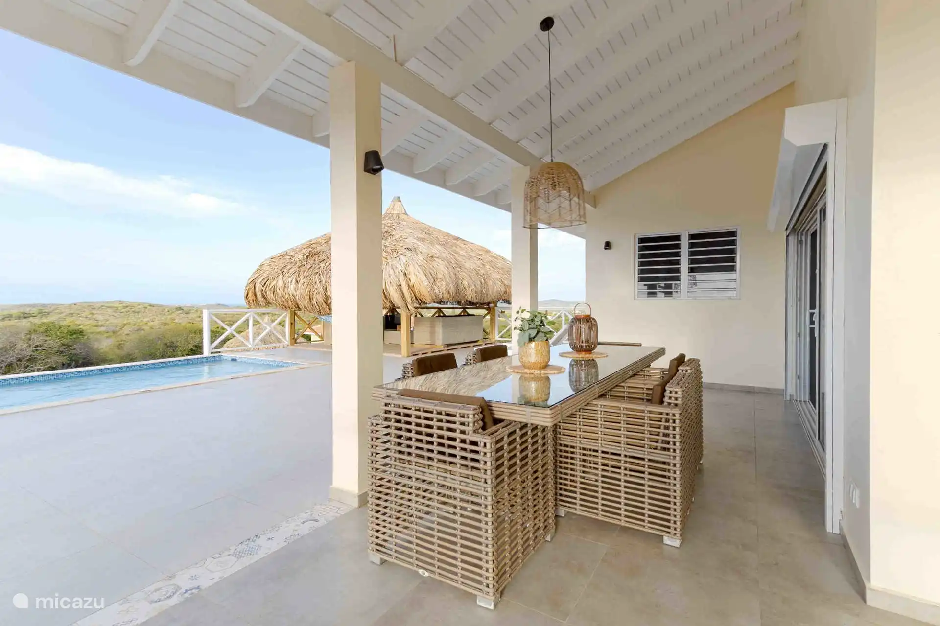 De ruime porch met een royale eettafel en prachtig zeezicht.