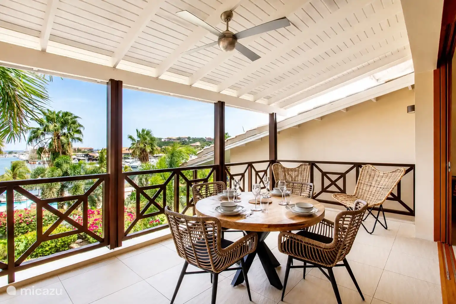 Spacious covered balcony with dining table and fan. Ideal for sitting comfortably outside with a view and a nice breeze.