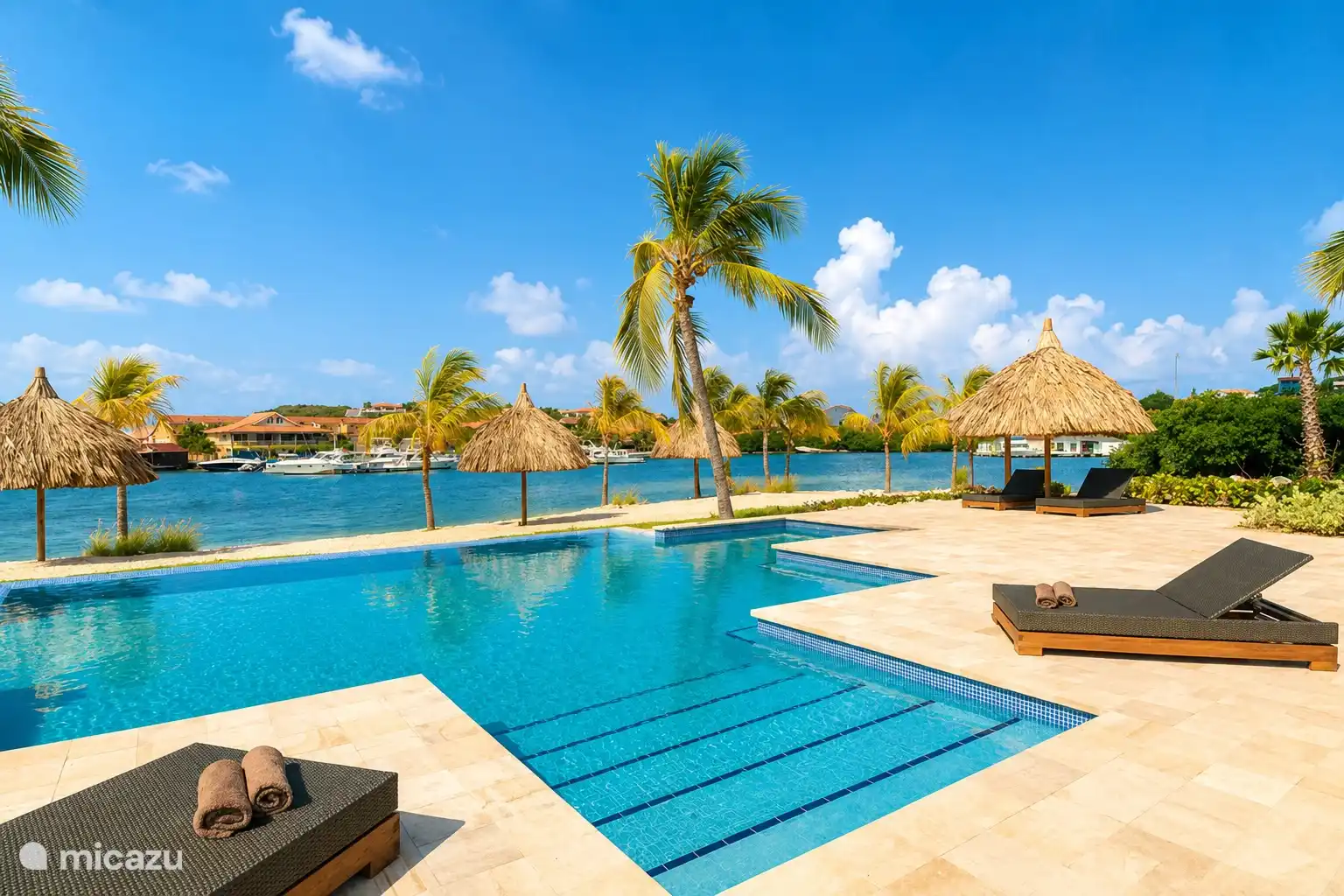 Swimming pool overlooking the Spanish Water, sunbeds and palapas for a relaxing day in the sun.