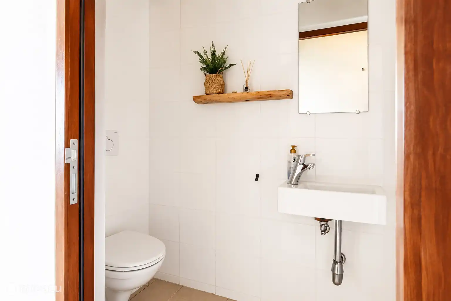 Neat toilet with sink and practical layout. Fresh and well-kept.