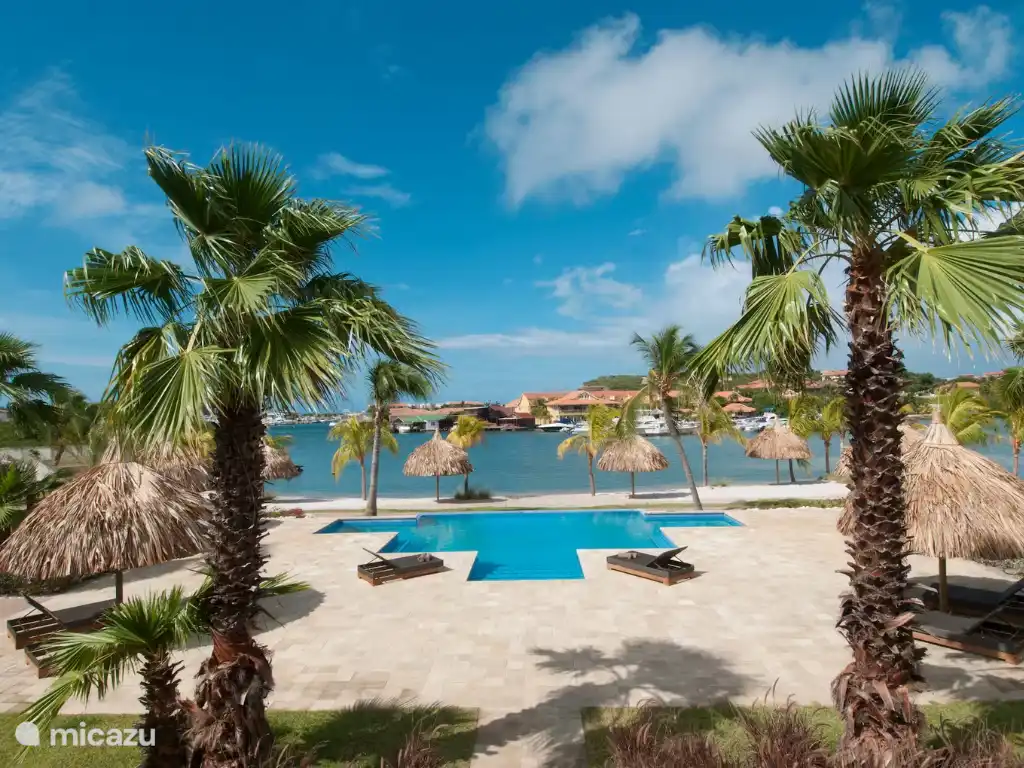     Ausblick über Pool, Palmen und spanisches Wasser, mit viel Platz zum Entspannen.