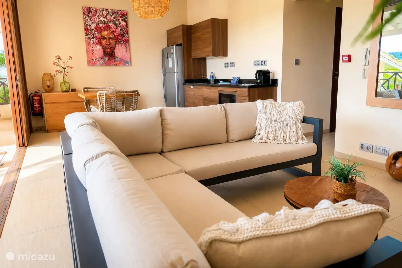 Living room with open kitchen and comfortable sitting area. Large sliding doors provide plenty of light and a fine connection to the outside.