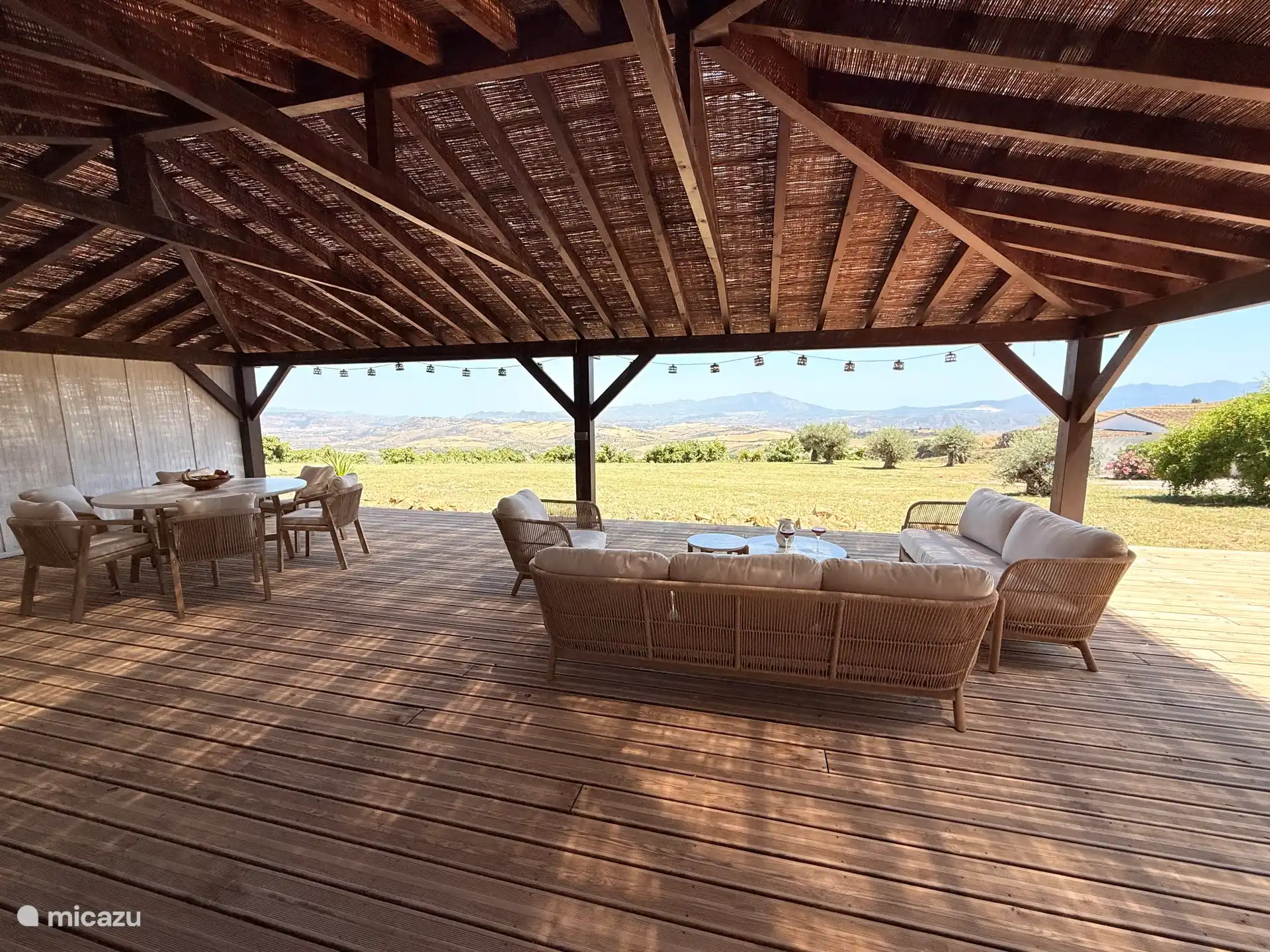 Loungebereich und Esstisch unter der Veranda. 