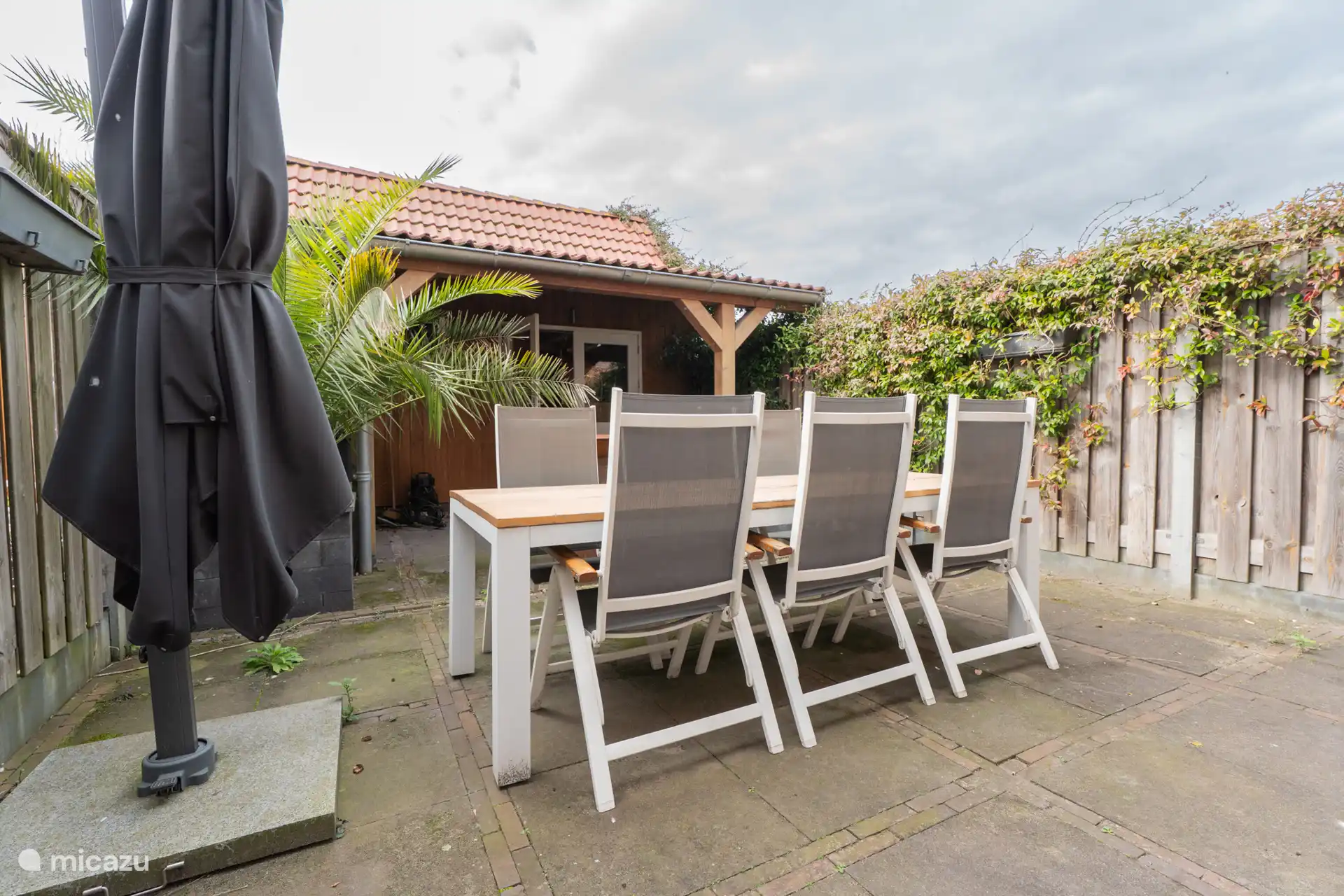 Eettafel in tuin met stoelen en overkapping