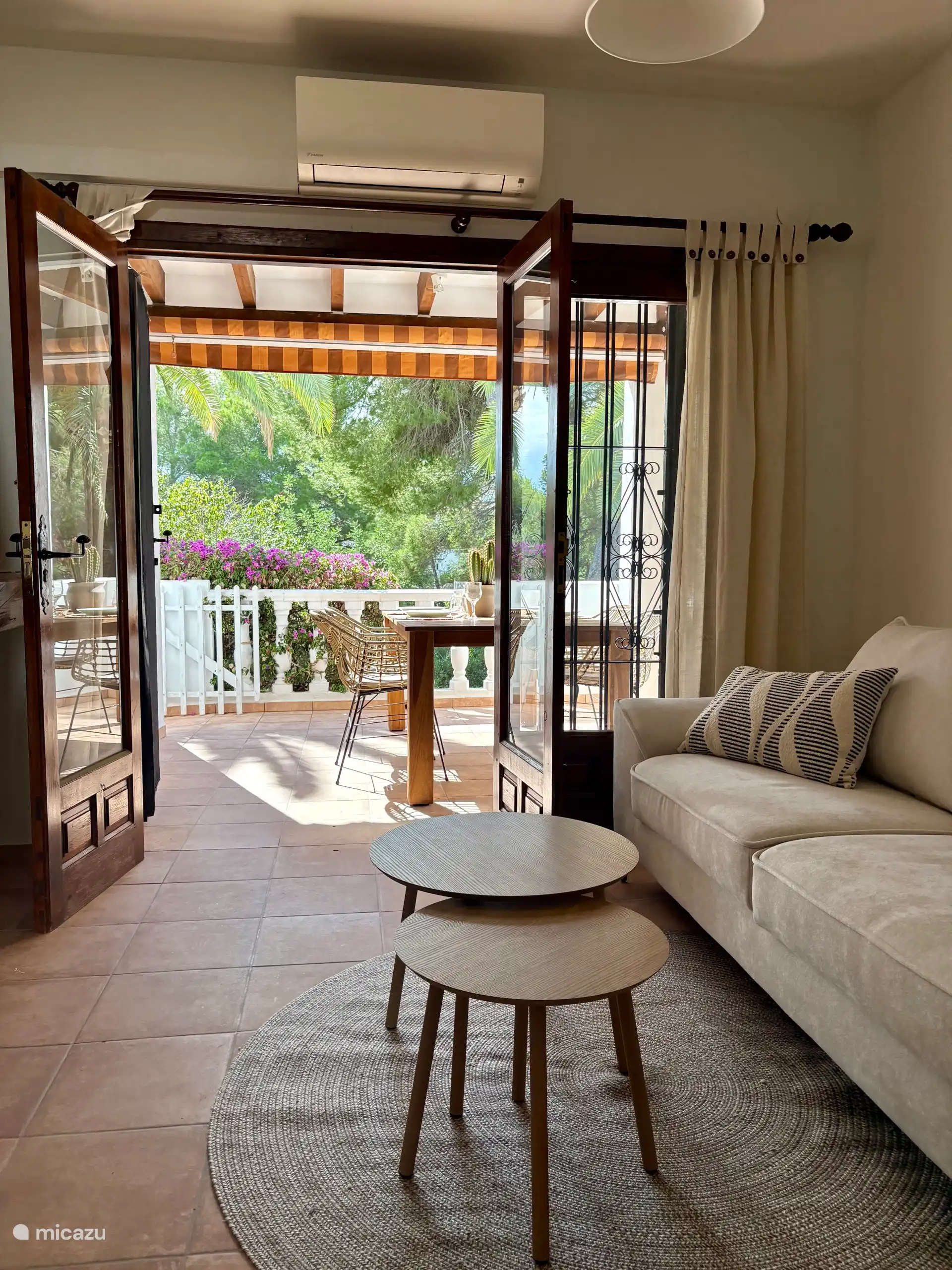 Living room with 3 seater sofa, air conditioning and a smart TV. Dining area with round dining table and 4 dining chairs. - Living-dining room