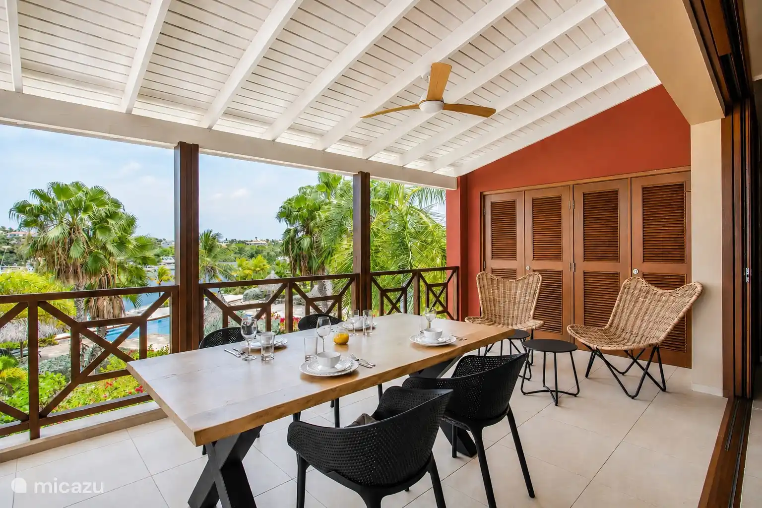 Amplia terraza cubierta con gran mesa de comedor, ideal para desayunar o cenar al aire libre.
