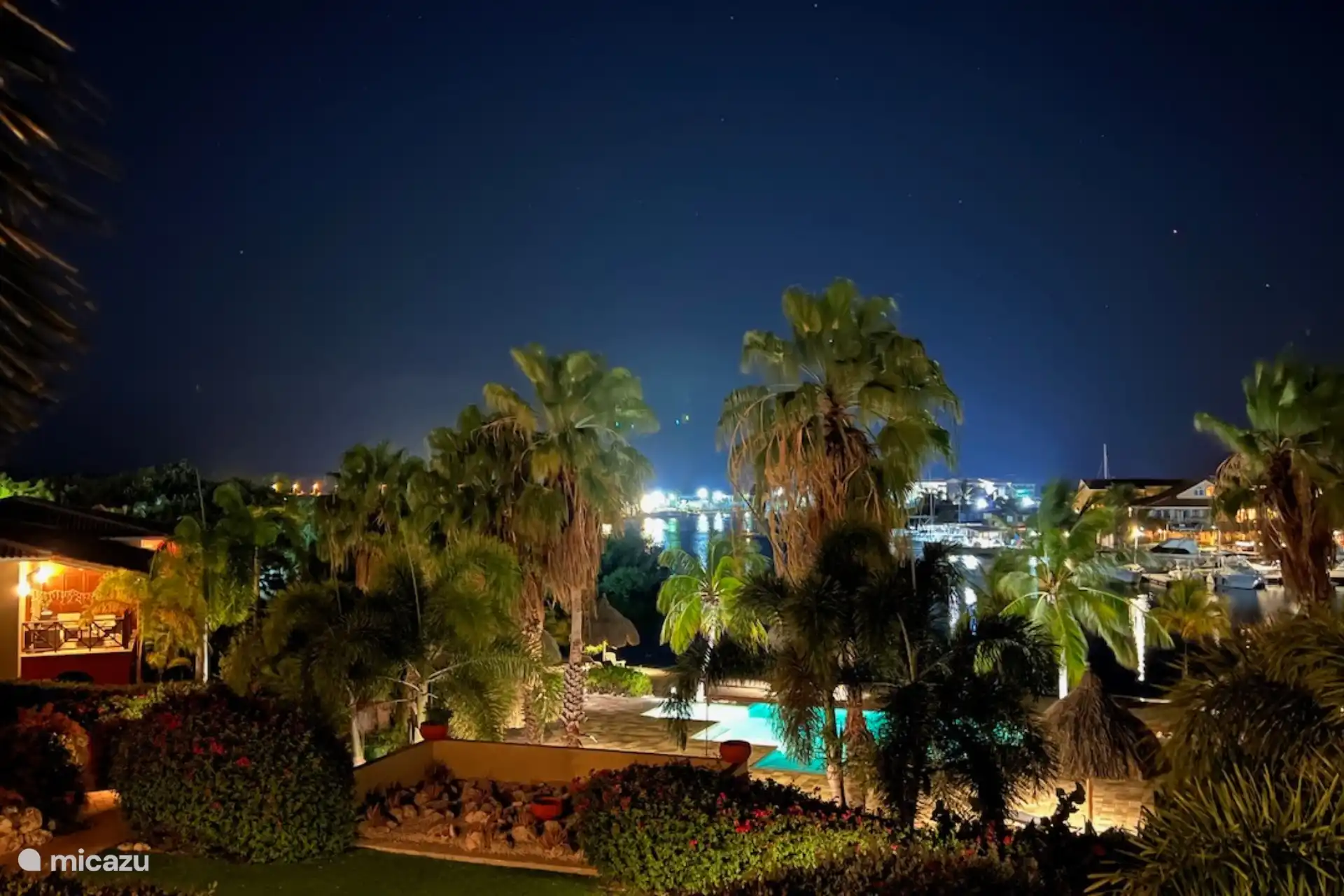 Abends mit beleuchtetem Pool und Palmen resortieren.