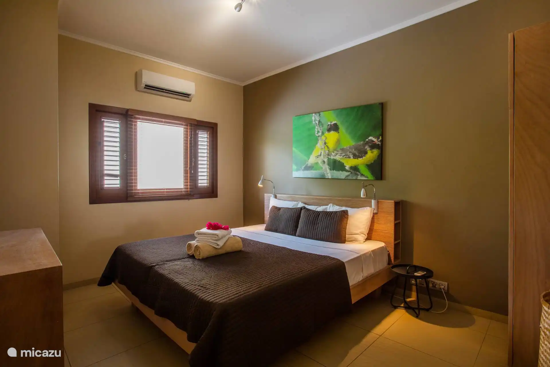Hauptschlafzimmer mit bequemem Bett und ruhigem Erscheinungsbild mit Klimaanlage.