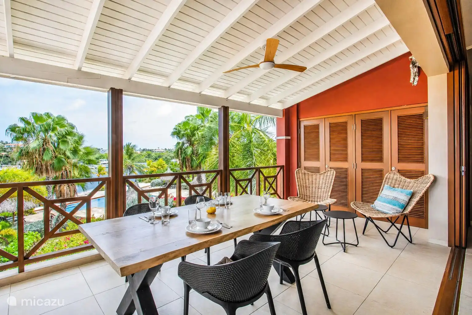 Geräumige überdachte Terrasse mit großem Esstisch, ideal zum Frühstück oder Abendessen draußen.