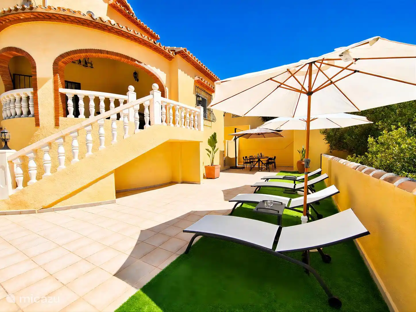 terrace with sunbeds and dining table