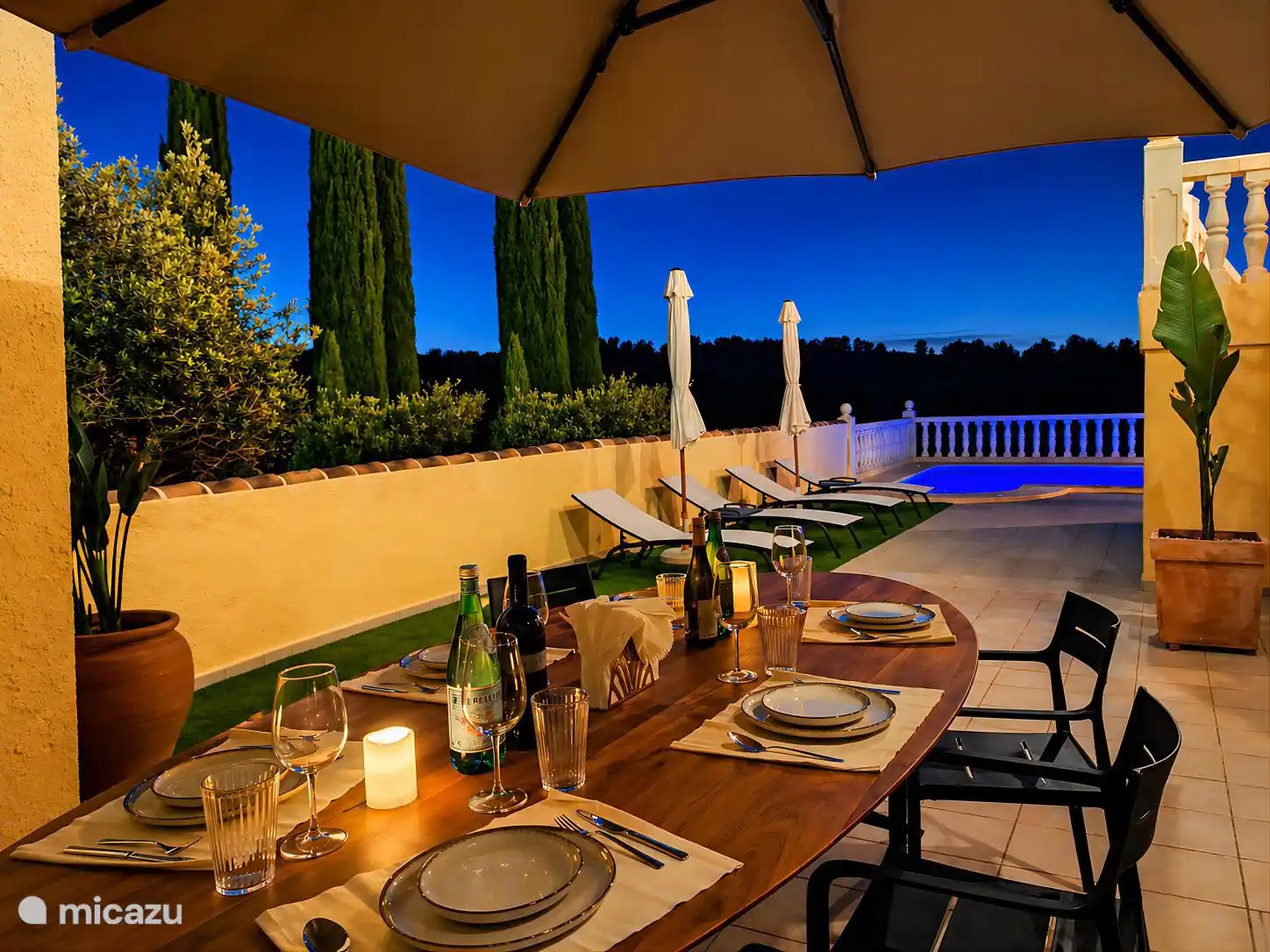 Terrace with dining table with sunbeds in the evening