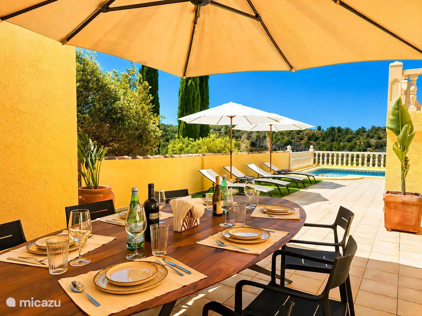 Terrace with dining table and sunbeds