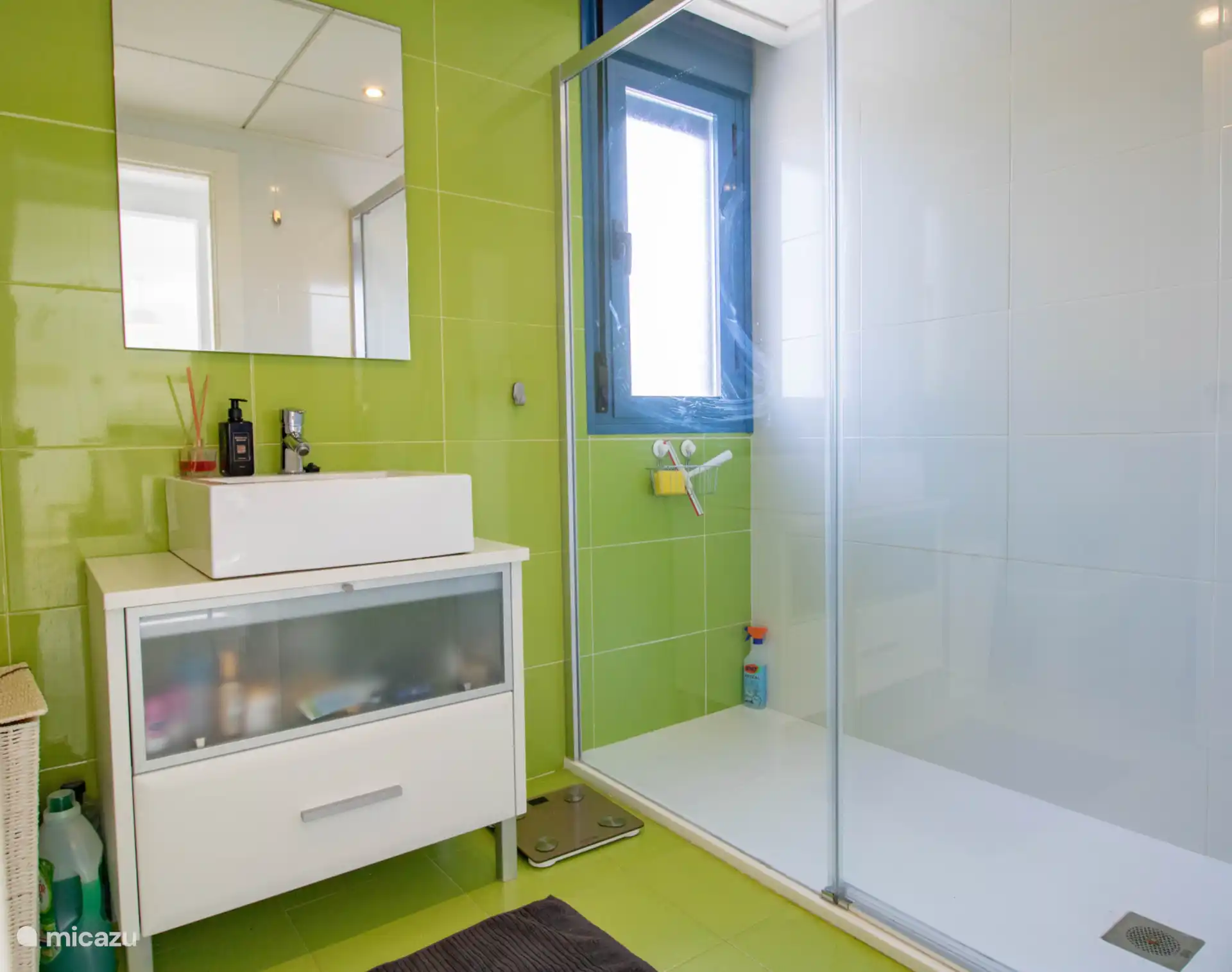 Frisse ruime badkamer met grote doucheruimte en een venster zodat je lekker kunt luchten
