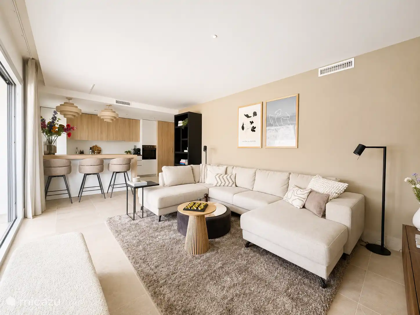 Ruime woonkamer met luxe open keuken en prachtig uitzicht op het terras en de omgeving