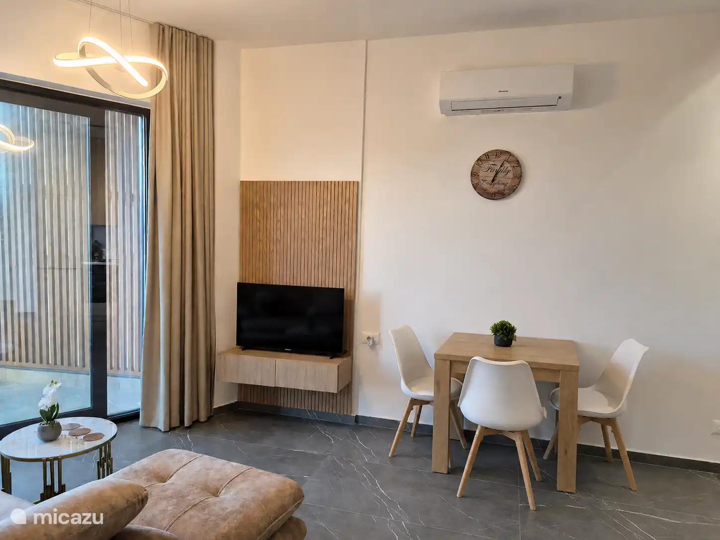 woonkamer met tv en eethoek