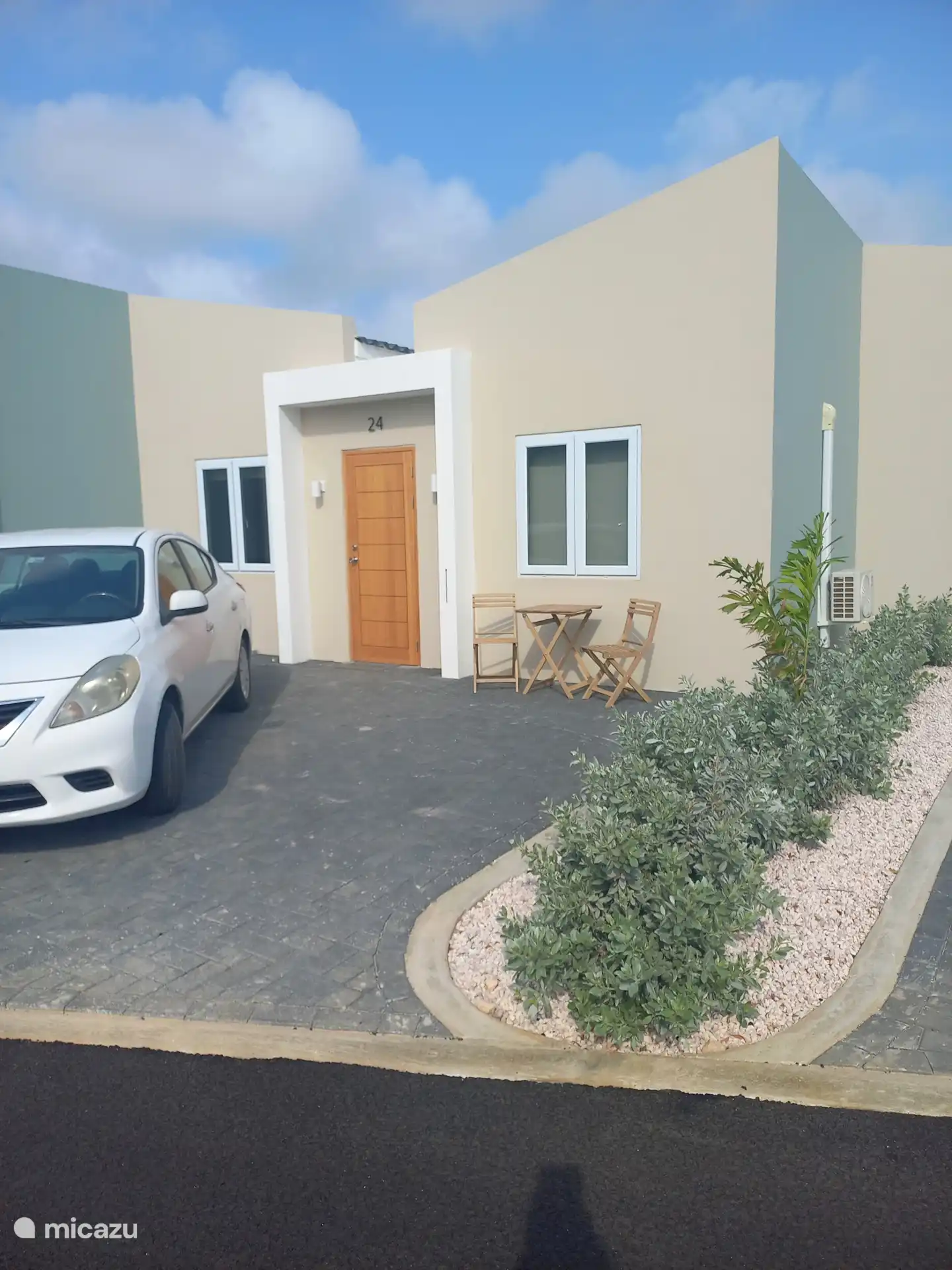 Voorkant van het huis met 2 parkeerplaatsen en een zithoekje