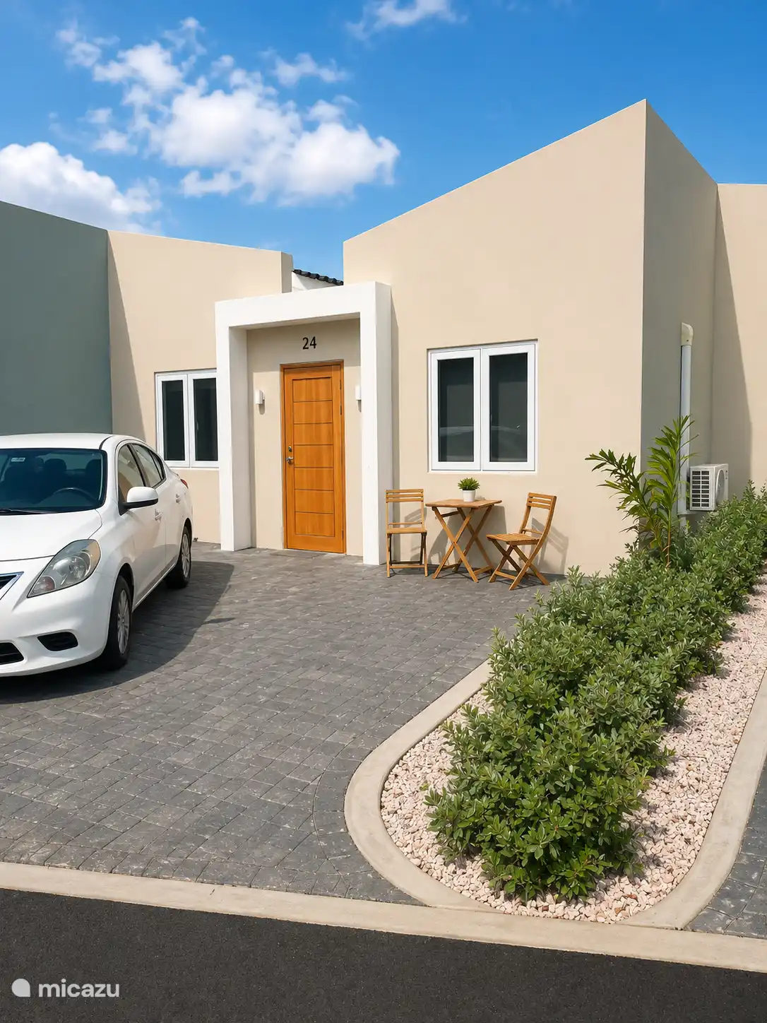Voorkant huis met zitje en plaats om 2 auto's te parkeren